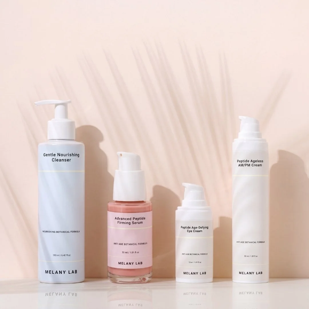 Four skincare bottles labeled Gentle Nourishing Cleanser, Advanced Peptide Firming Serum, Peptide Age-Defying Eye Cream, and Peptide Ageless AM/PM Cream from Melany Lab, arranged on a flat surface with shadowed background.