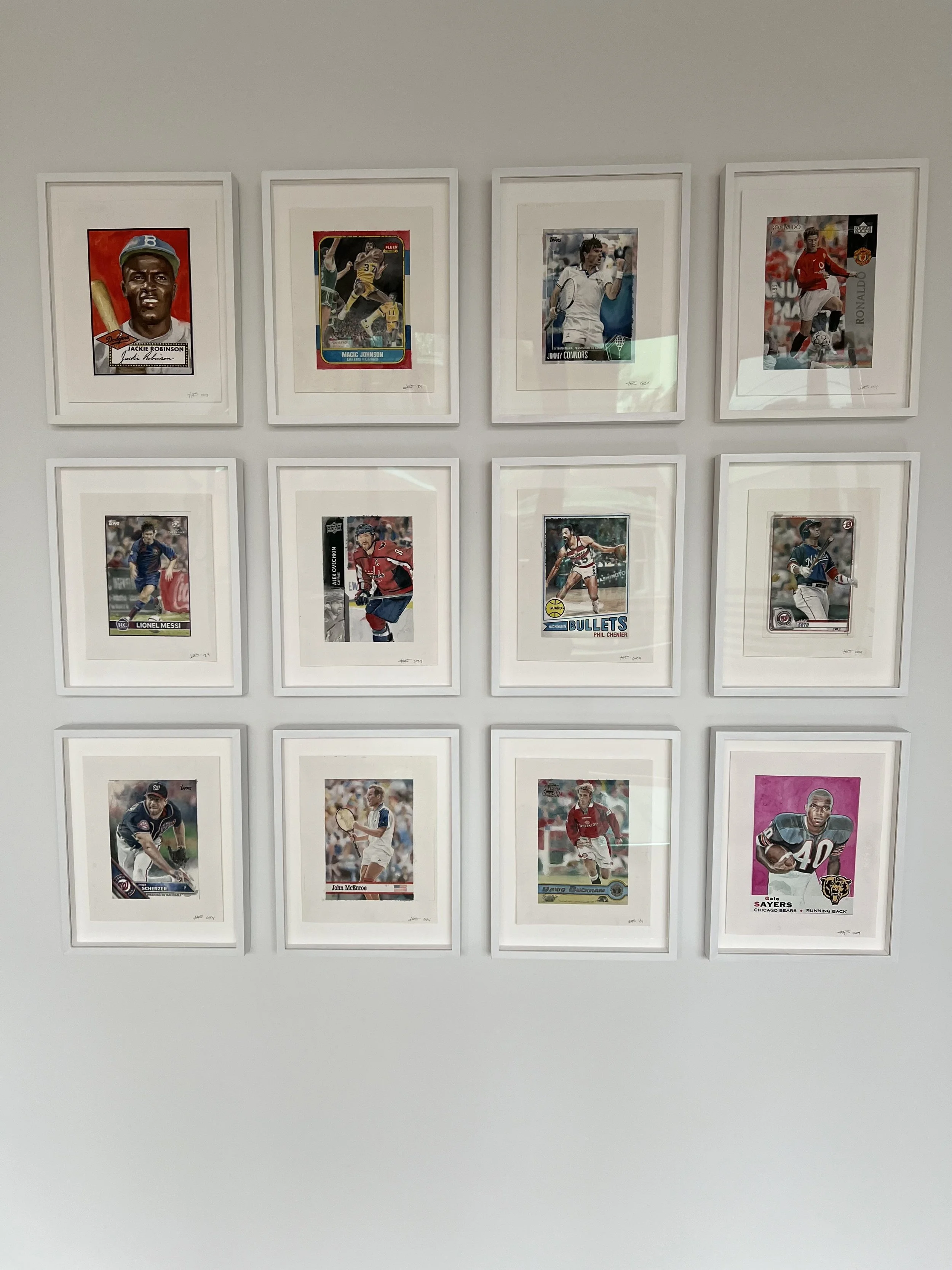 Framed sports trading cards arranged in two rows with five frames in each row on a white wall.