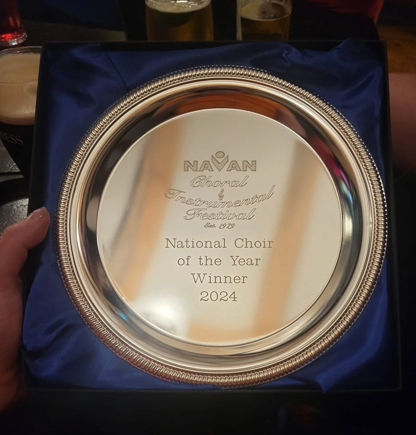 A silver and gold award plaque with text for the Navan Choral and Instrumental Festival 2024, recognizing the National Choir of the Year Winner.