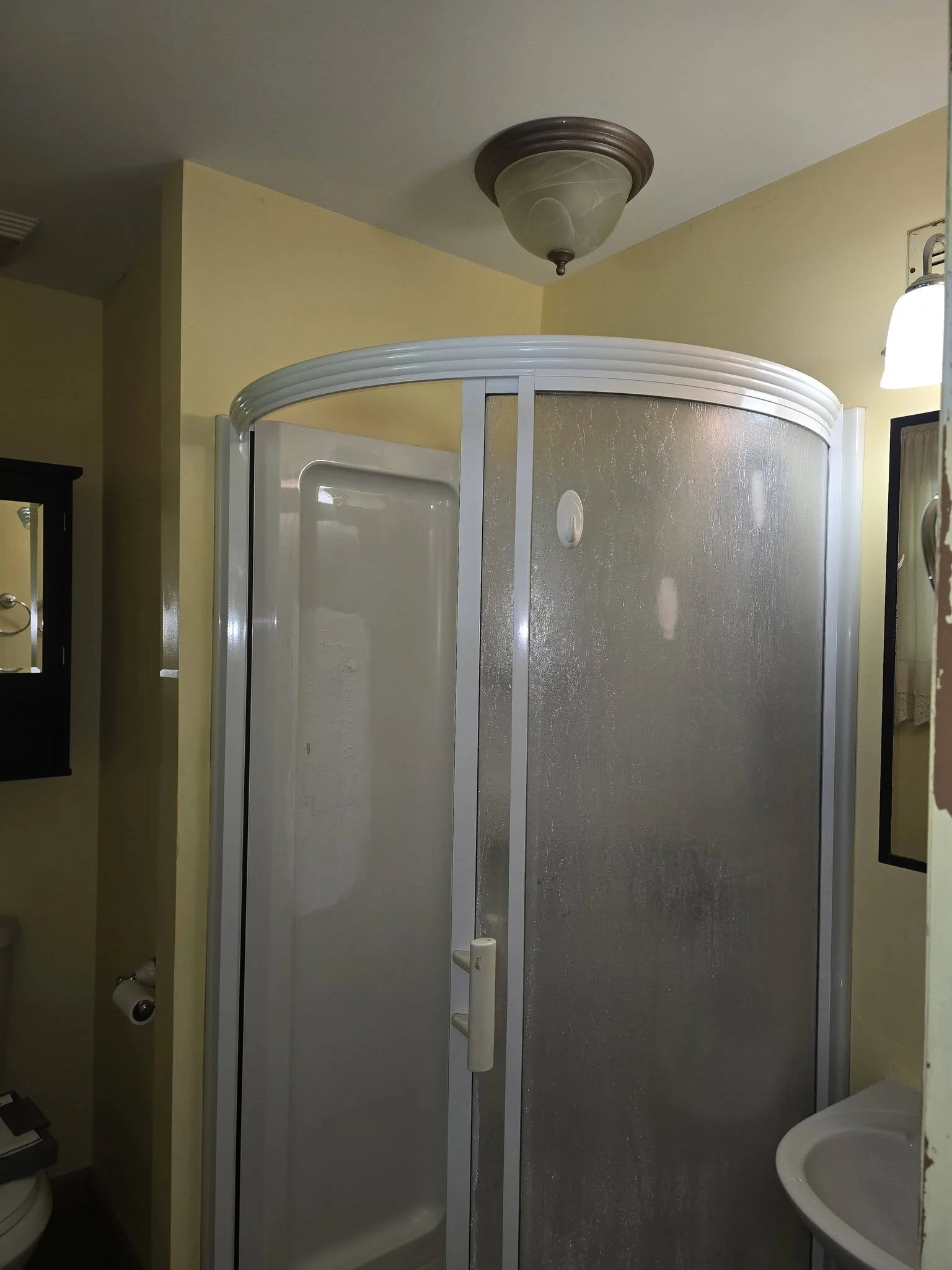 Top view of the old round shower stall and ceiling light before removal