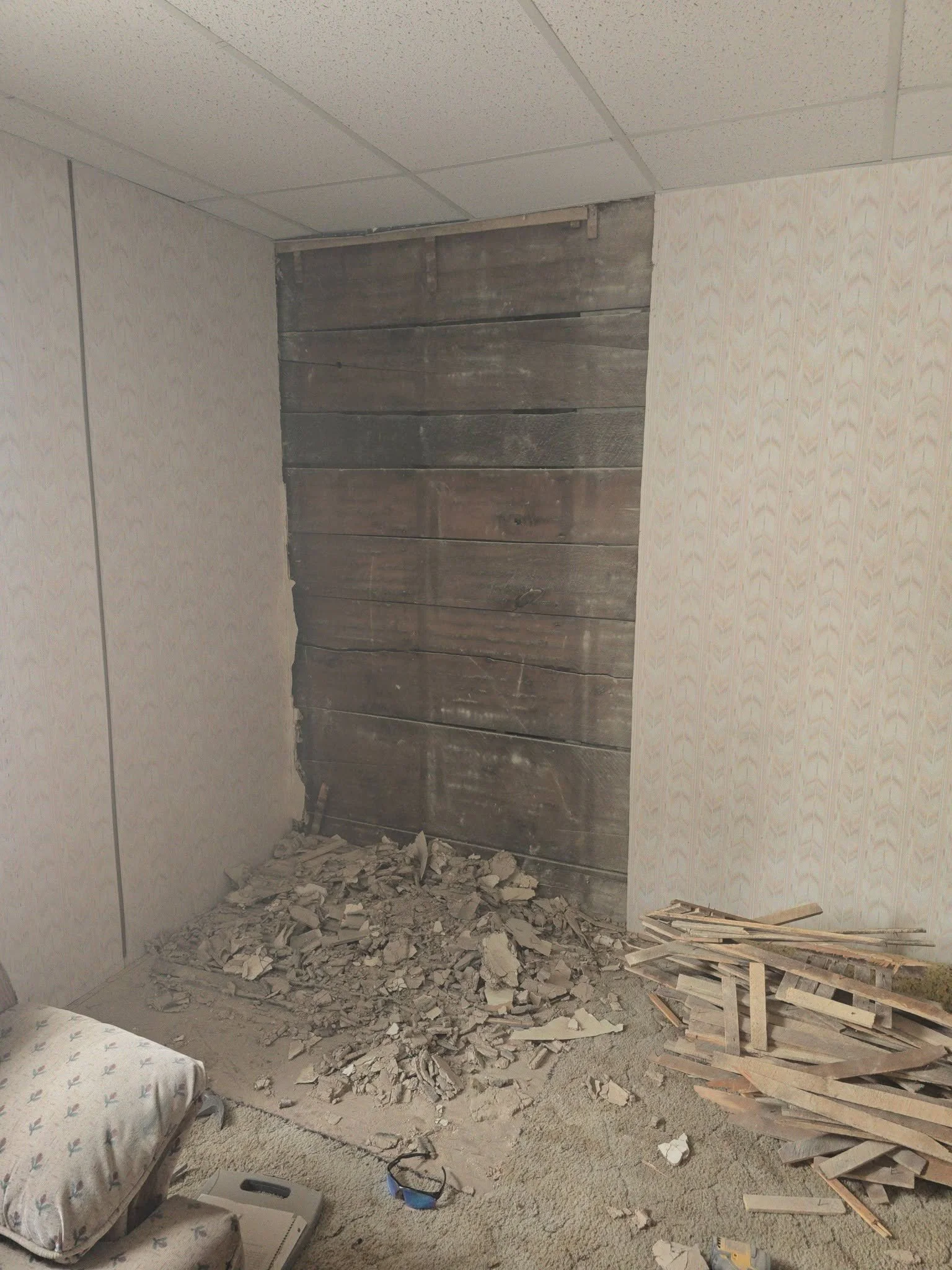 Old wall paneling removed and rubble on the floor during demolition