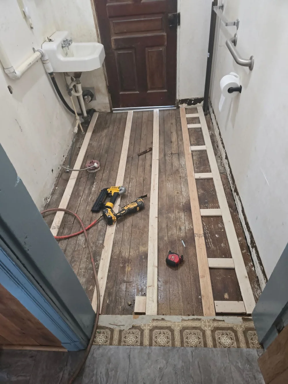 Floor opened up, with the original wall sink still in place.