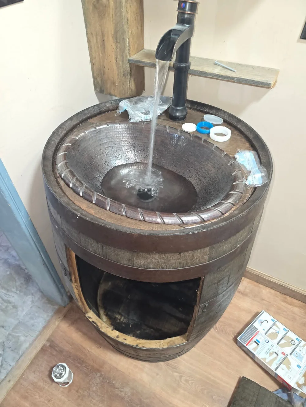 The bowl and faucet are fitted. The access opening is still uncovered.