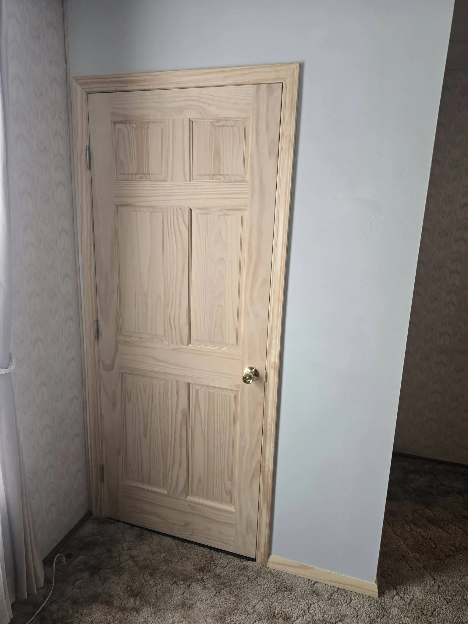 The new pine door closed, blending into the living room wall