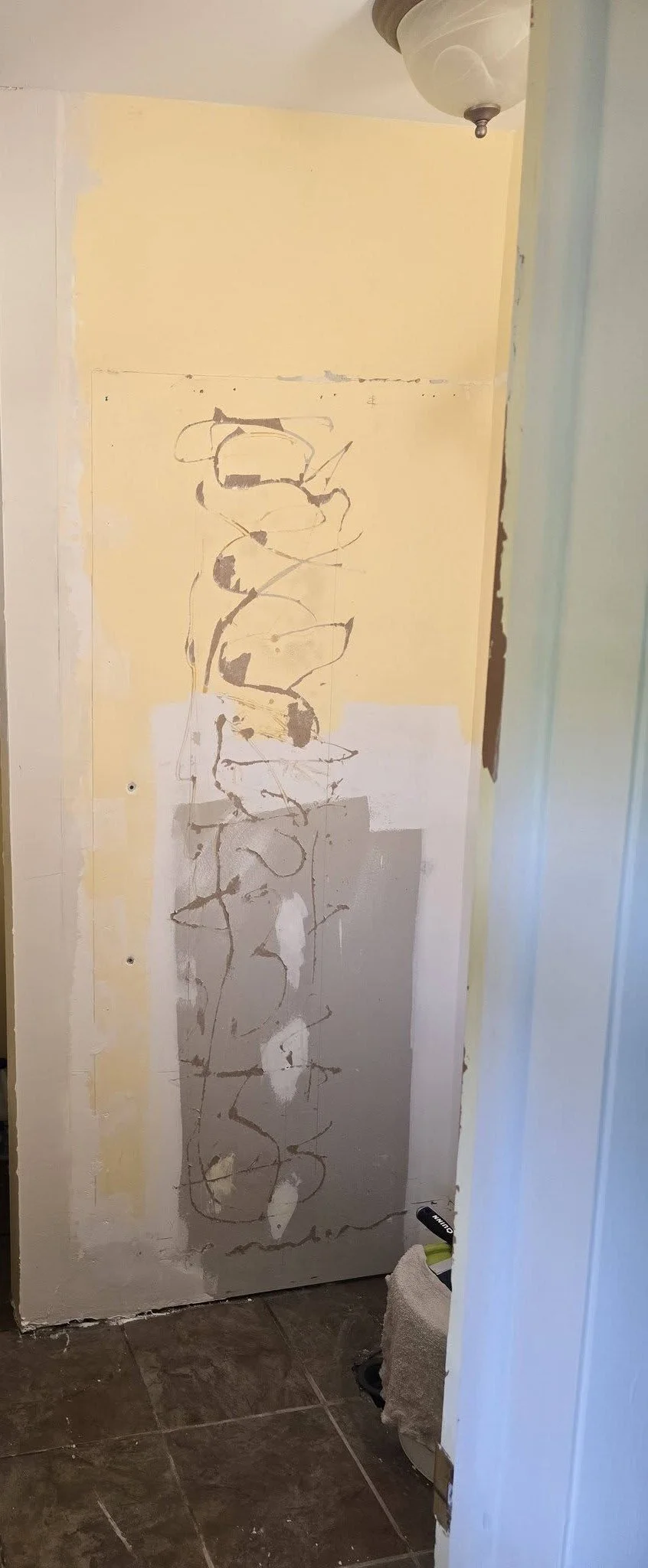 The bathroom with the old stall removed and the wall being prepped