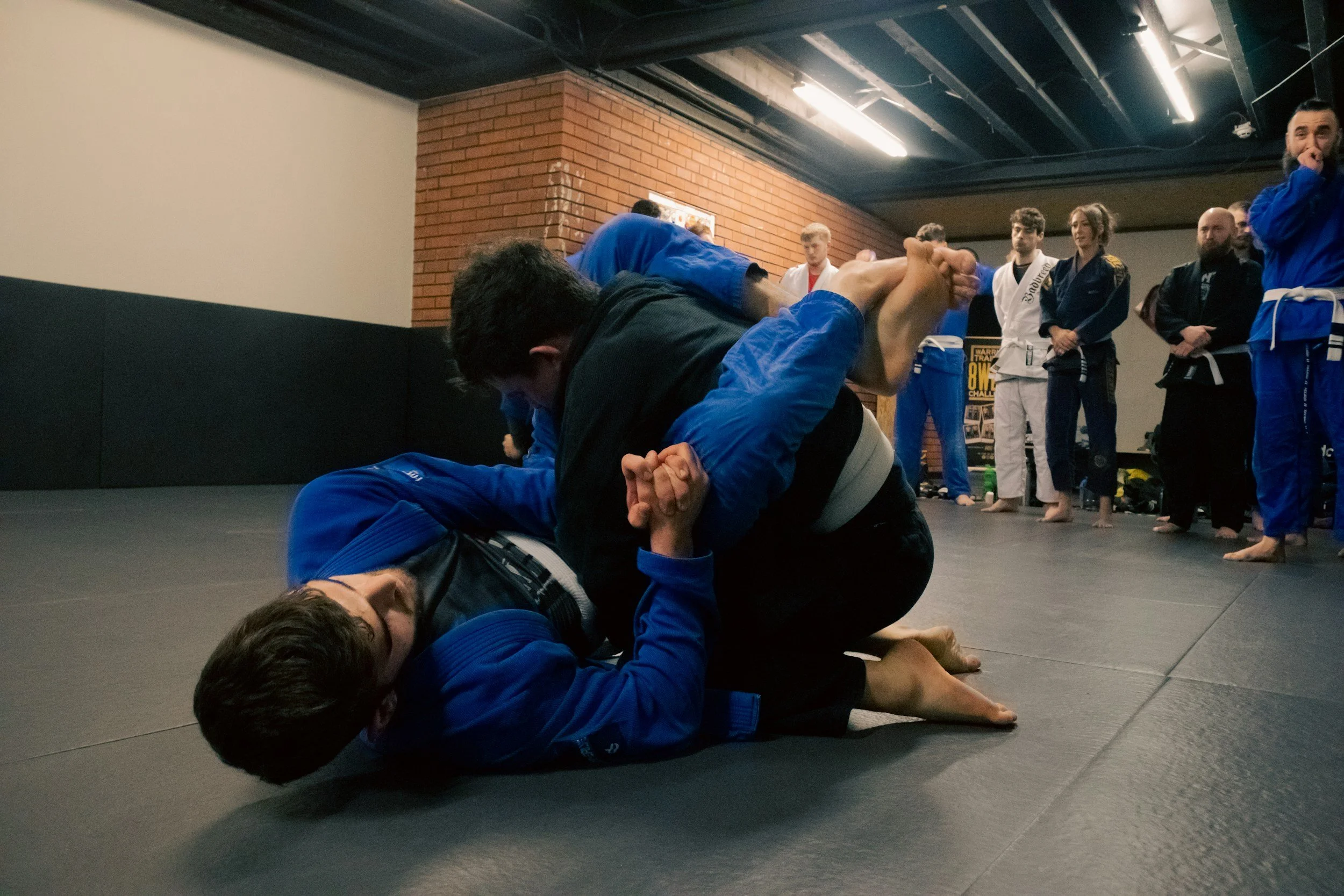 Two men engaged in a jiu jitsu class