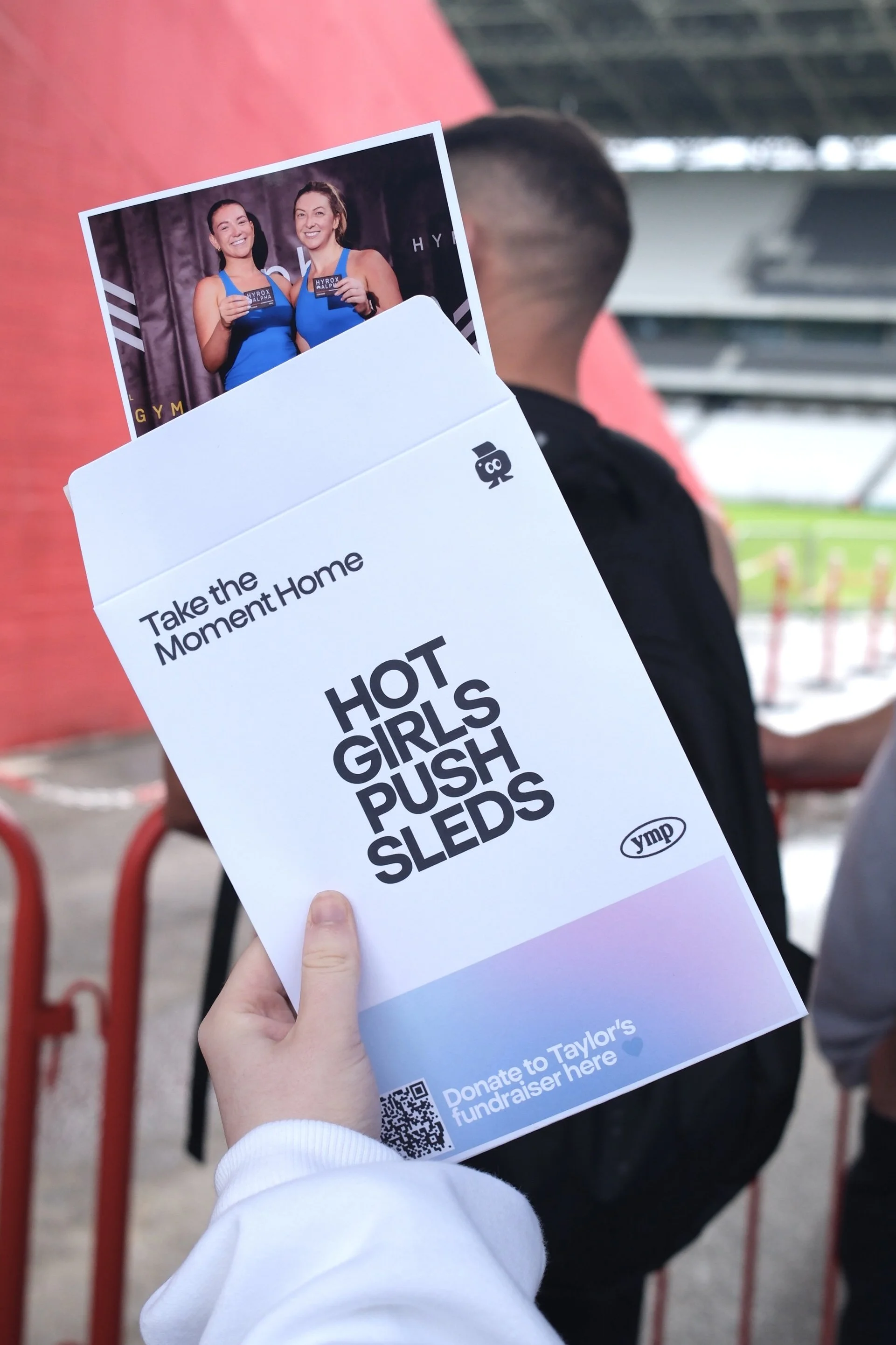 Hot Girls Push Sleds print envelope held up at the stadium