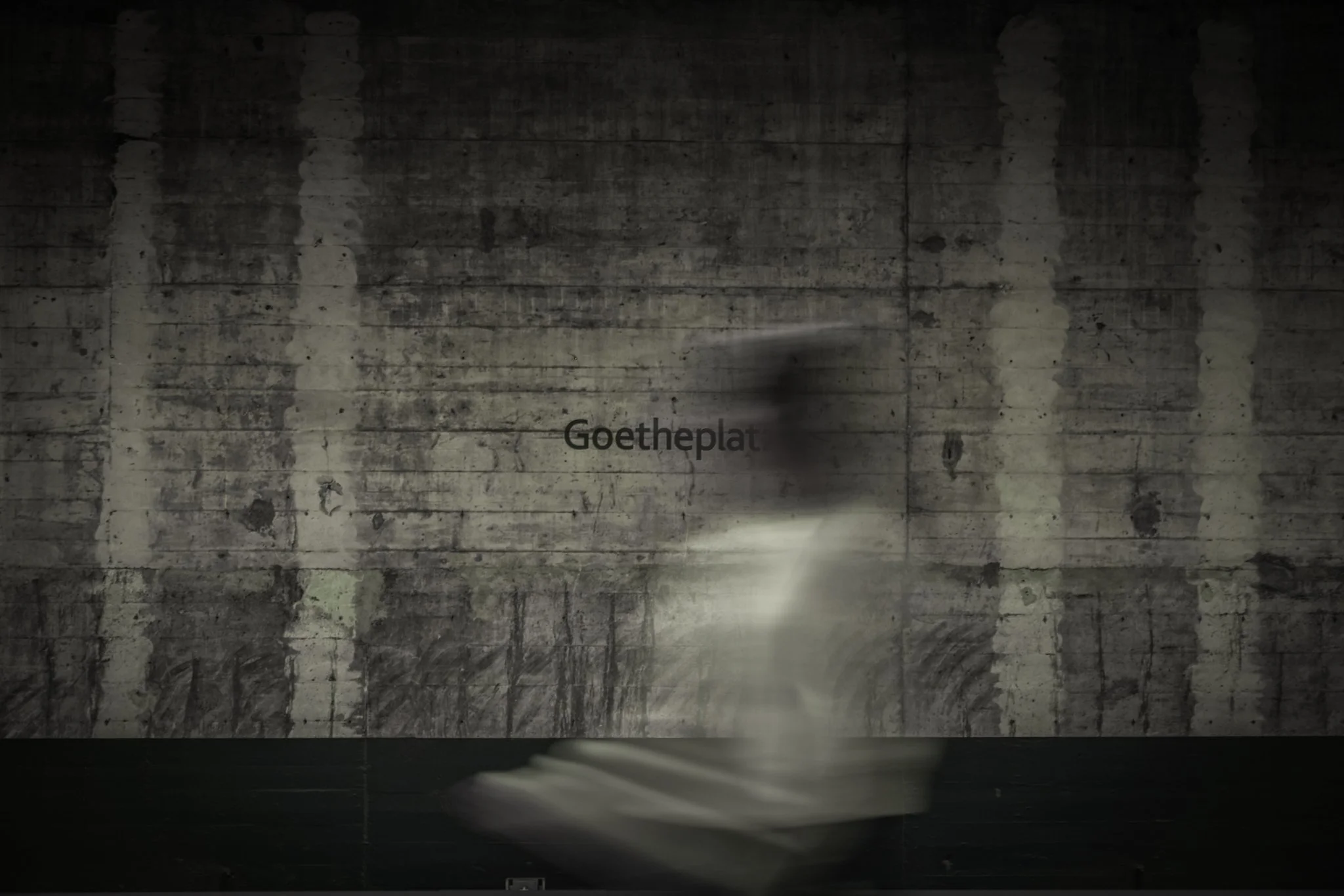 Photo of the large industrial-style wall art with the word 'Goetheplatz' painted on the concrete wall.