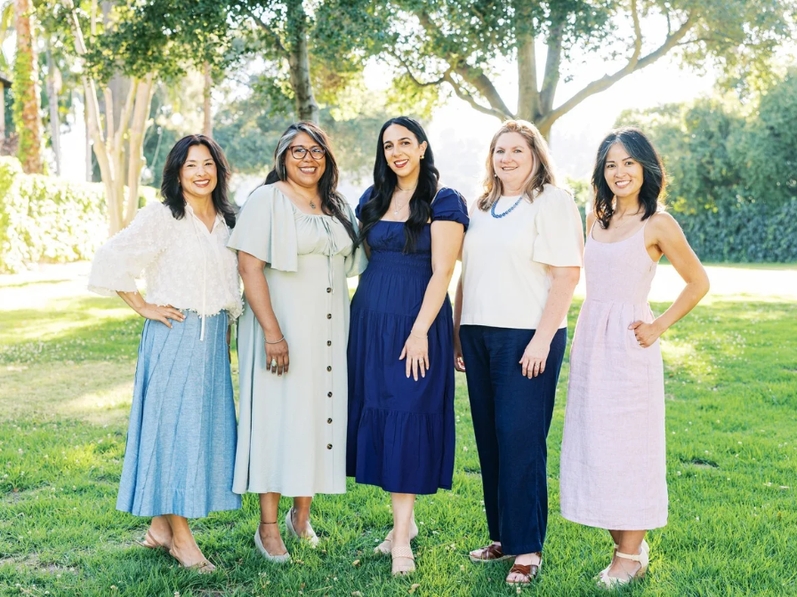 Five members of Village East standing together outdoors.