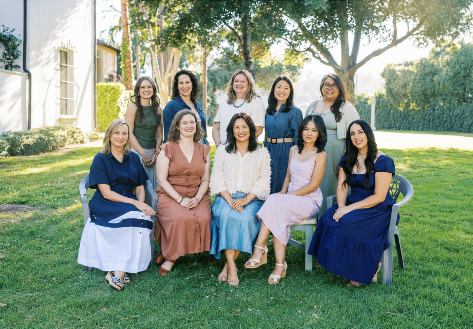Ten Village Therapy Collective therapists posing together outdoors beneath a large tree.