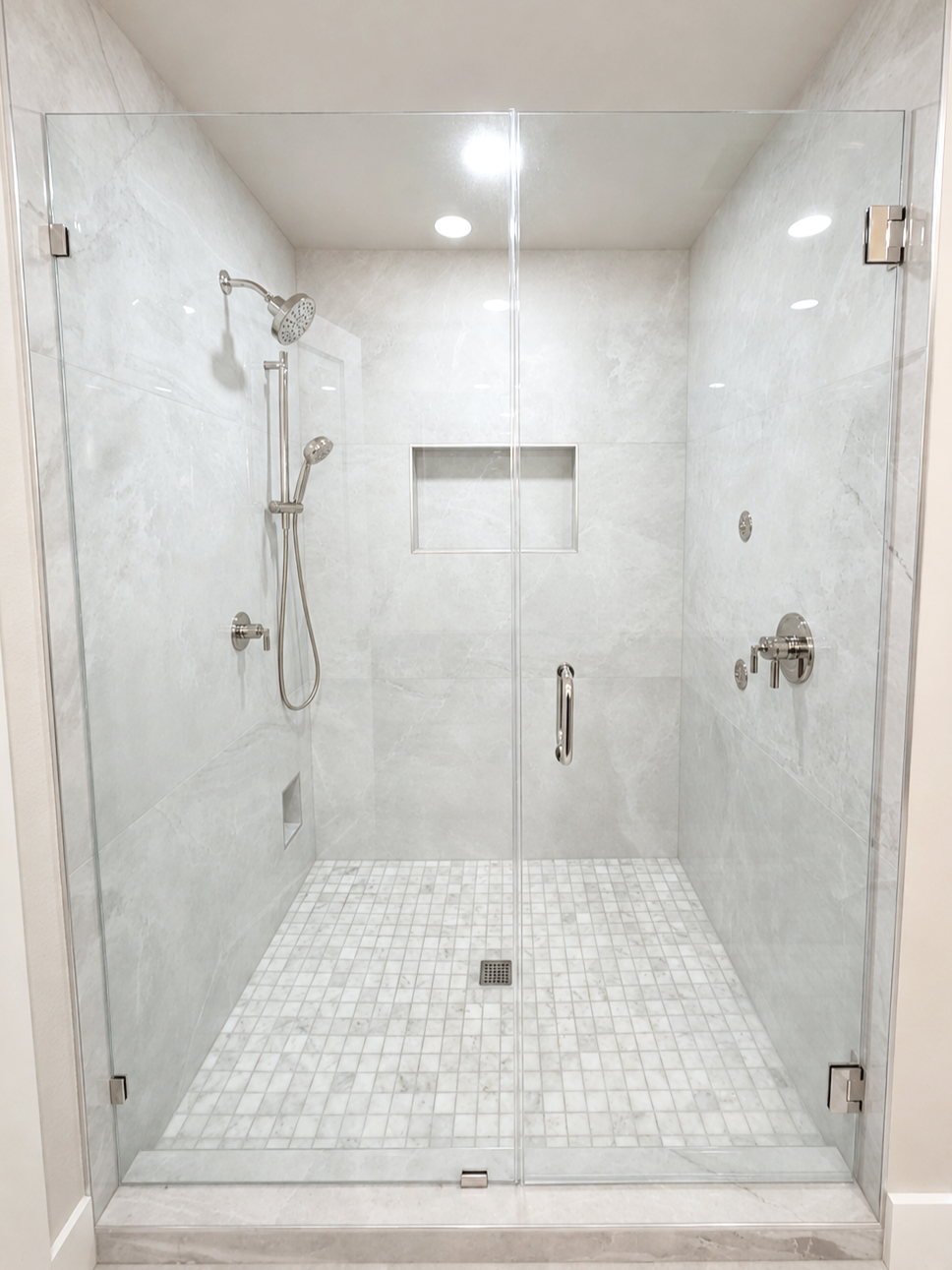 Bathroom renovation with white tile shower surround, built-in niche, and polished nickel shower fixtures.