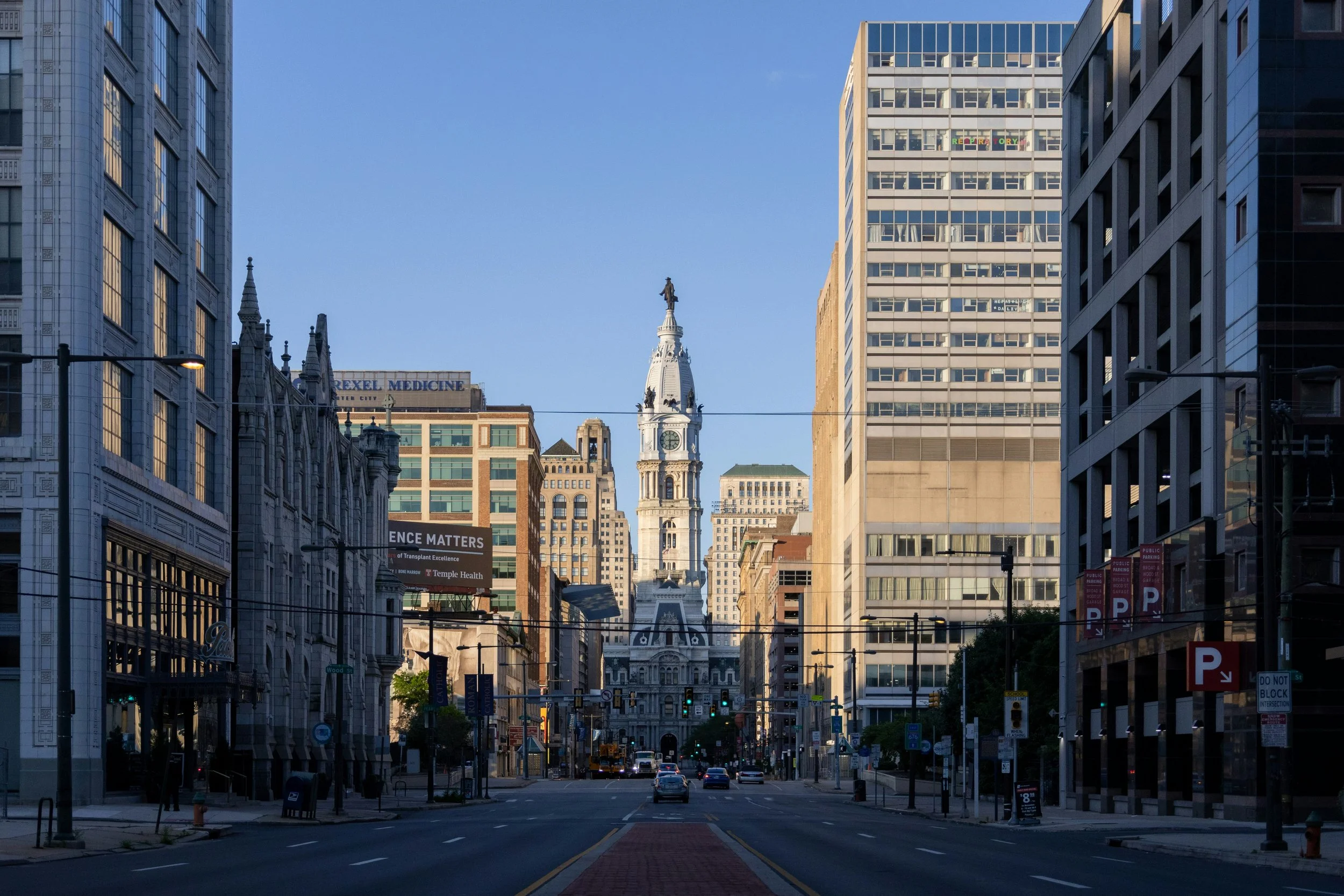 Philadelphia city street with Philadelphia City Hall clock tower framed by downtown buildings