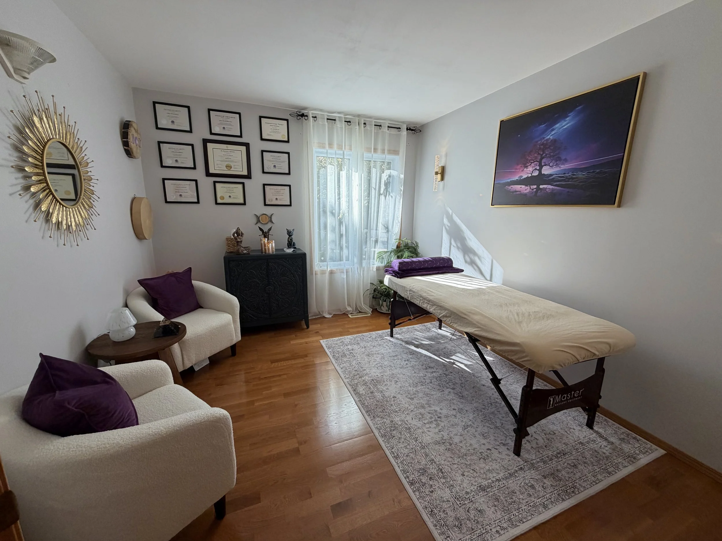 Stonewall healing room at Stardust & Sol, with a treatment table, cream seating and natural light.