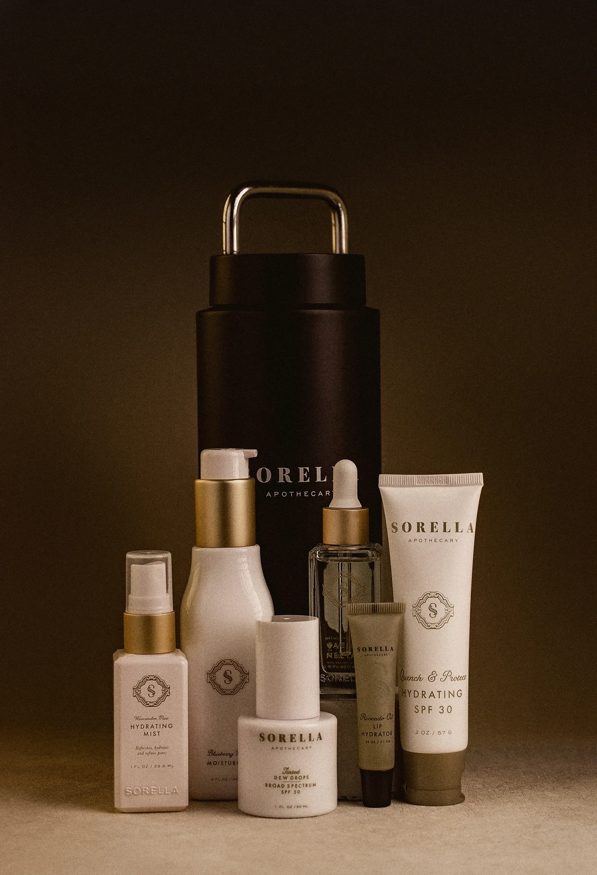 Collection of skincare products including hydrating mist, moisturizer, lip hydrator, hydrating spray, and SPF 30, with a dark background and beige surface.