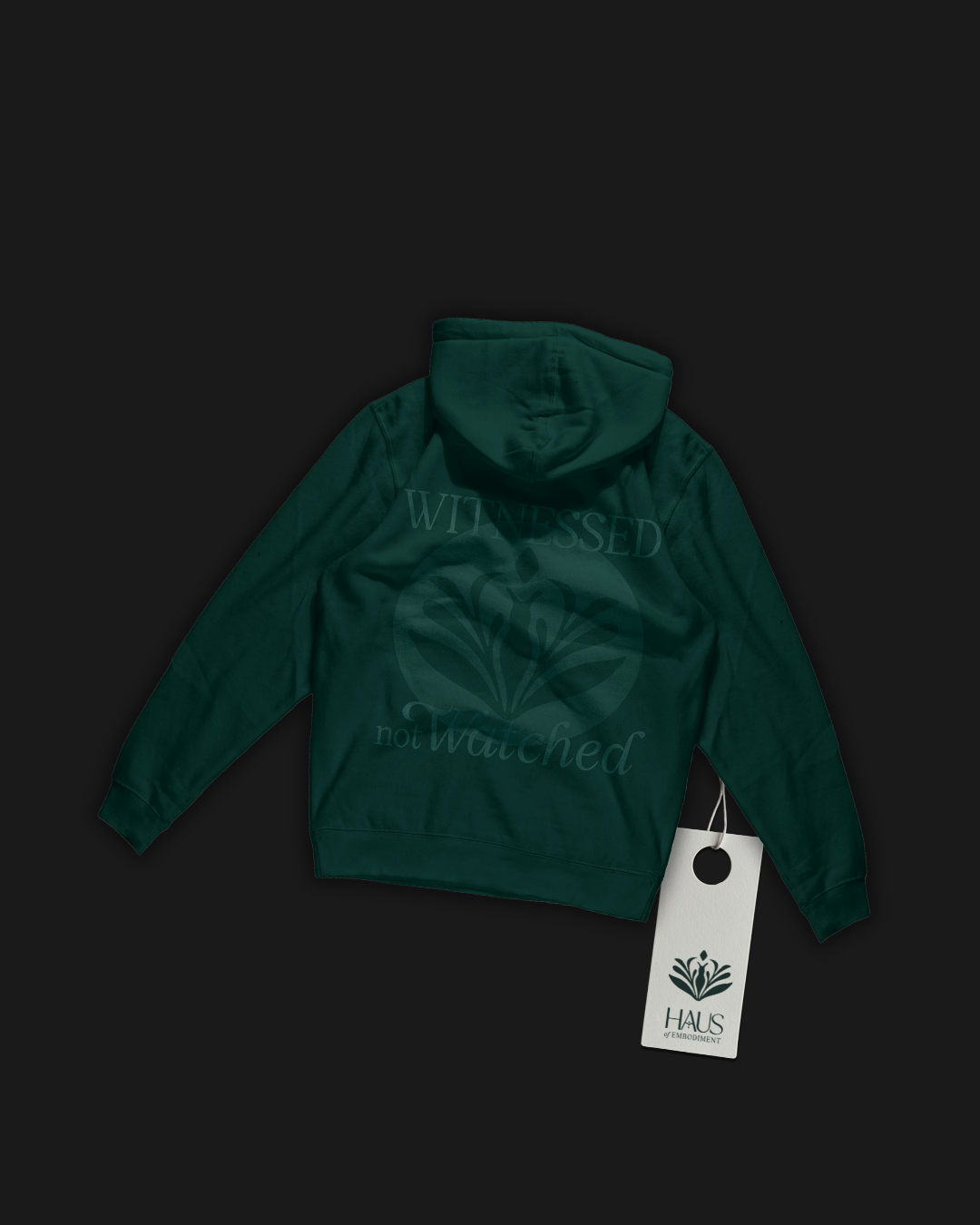Dark green hoodie with a floral logo and the words 'WITNESSED not Watched' printed on the back, displayed against a black background with a white tag attached.