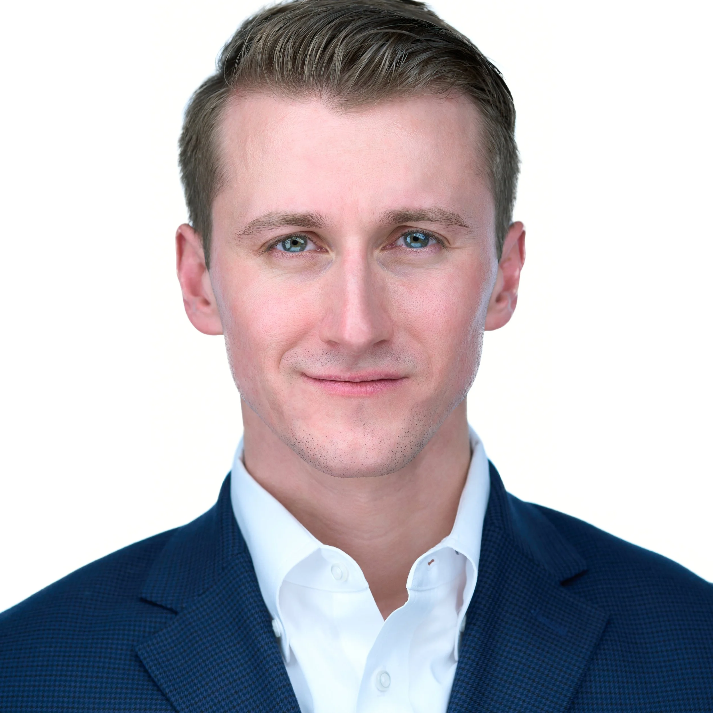 DAVIDSAGGIO Photography Tampa male entrepreneur portrait. Tight smile, hair combed back. White button down with navy sport coat. White background.