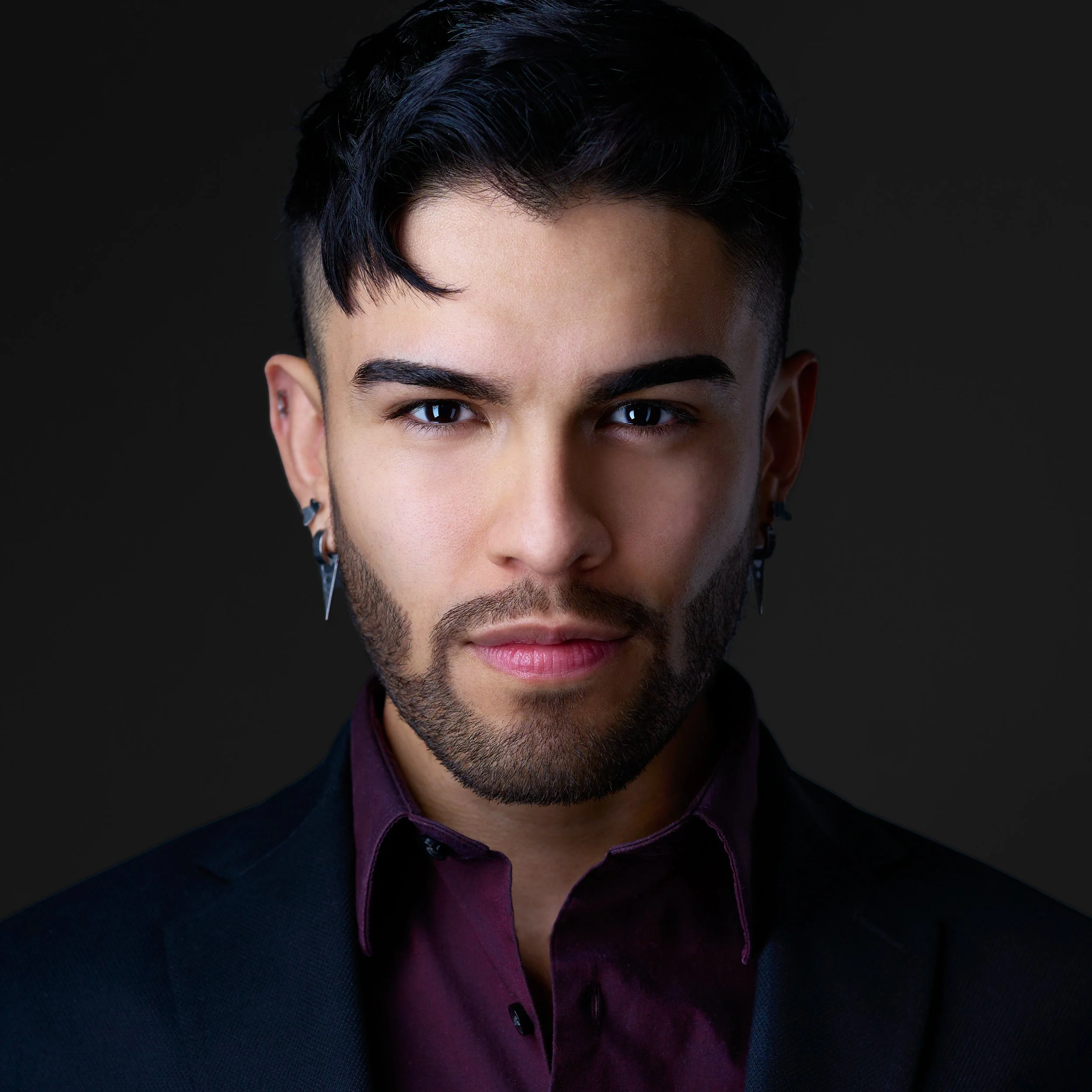 DAVIDSAGGIO Photography Tampa male entrepreneur portrait, wearing a purple shirt and black jacket on a black background.