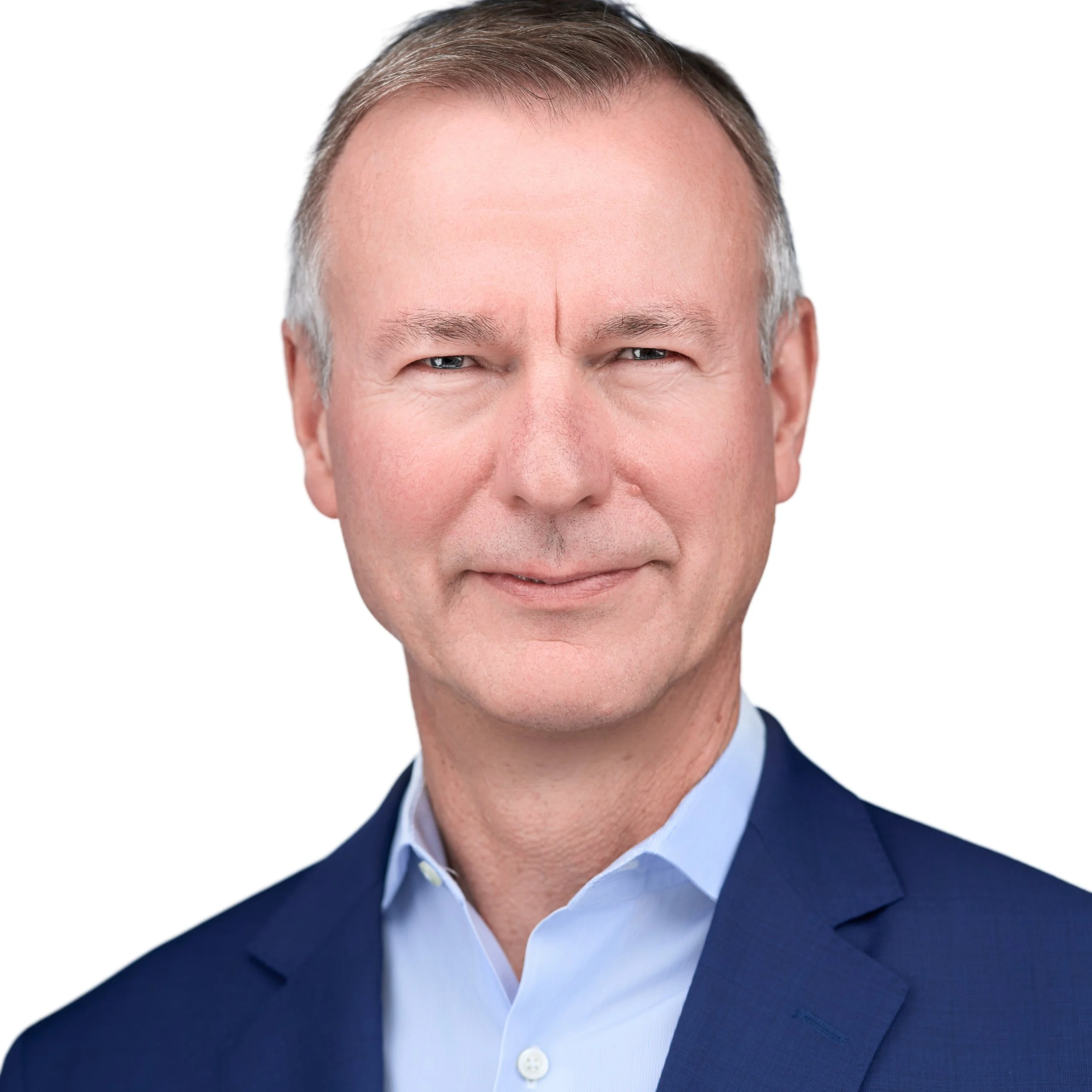 Senior male executive leader headshot. Slightly gray hair, blue button down, and blue jacket on white background. DAVIDSAGGIO Photography Tampa