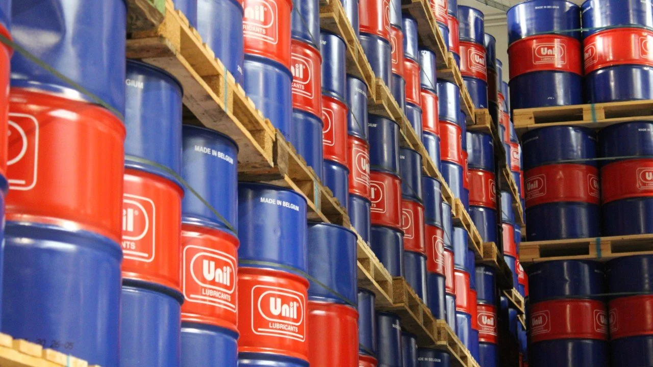 Stacks of blue and red drums labeled "Ufi Lubricants" on wooden pallets in a warehouse.