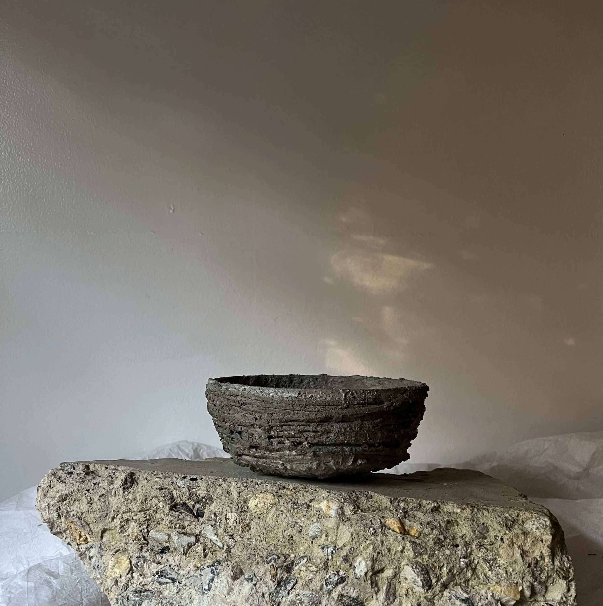 Stacked slabs of different types of granite and stone, displayed against a plain background.