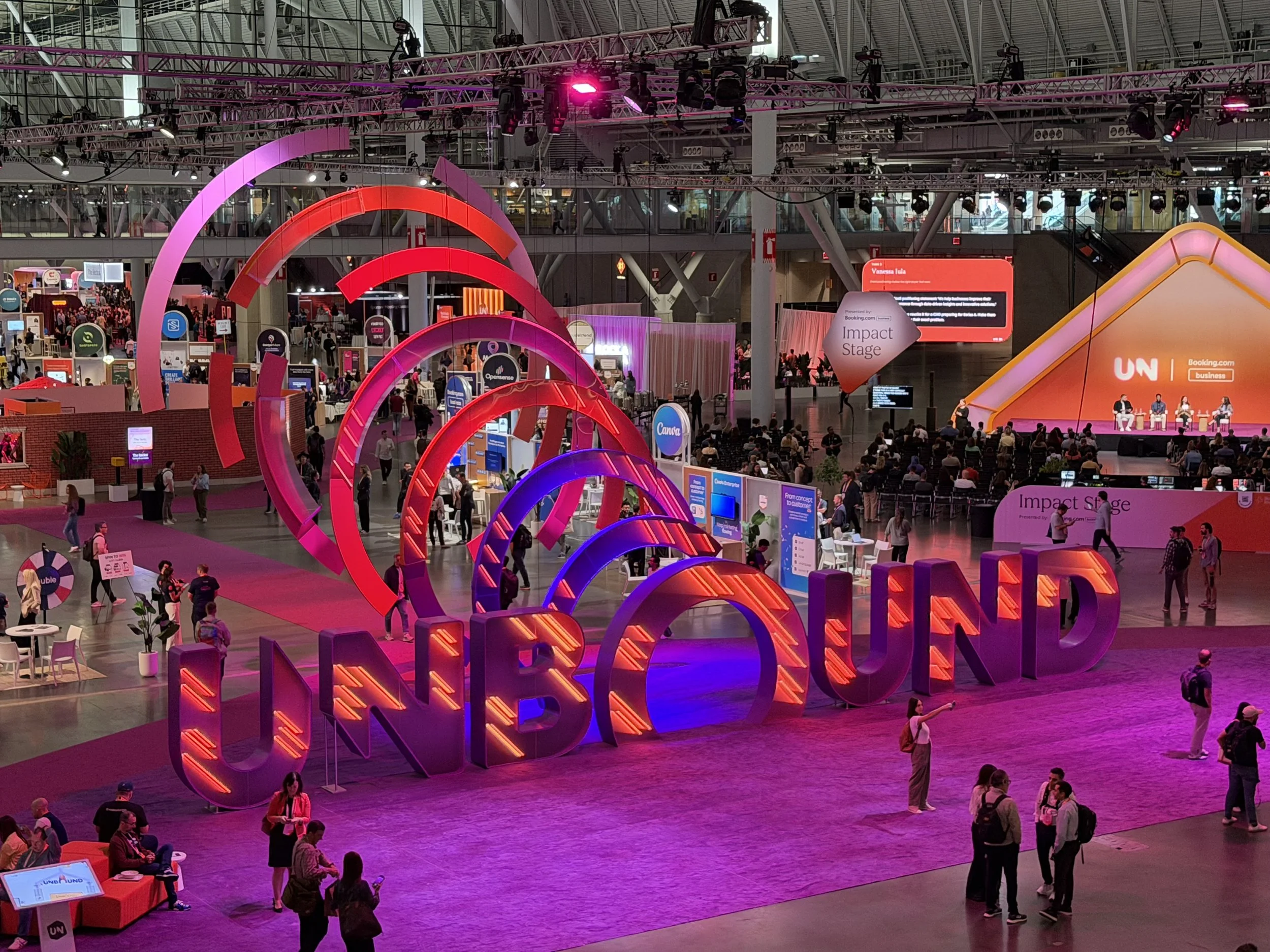 Expo floor at HubSpot’s UNBOUND conference, with a giant illuminated sign