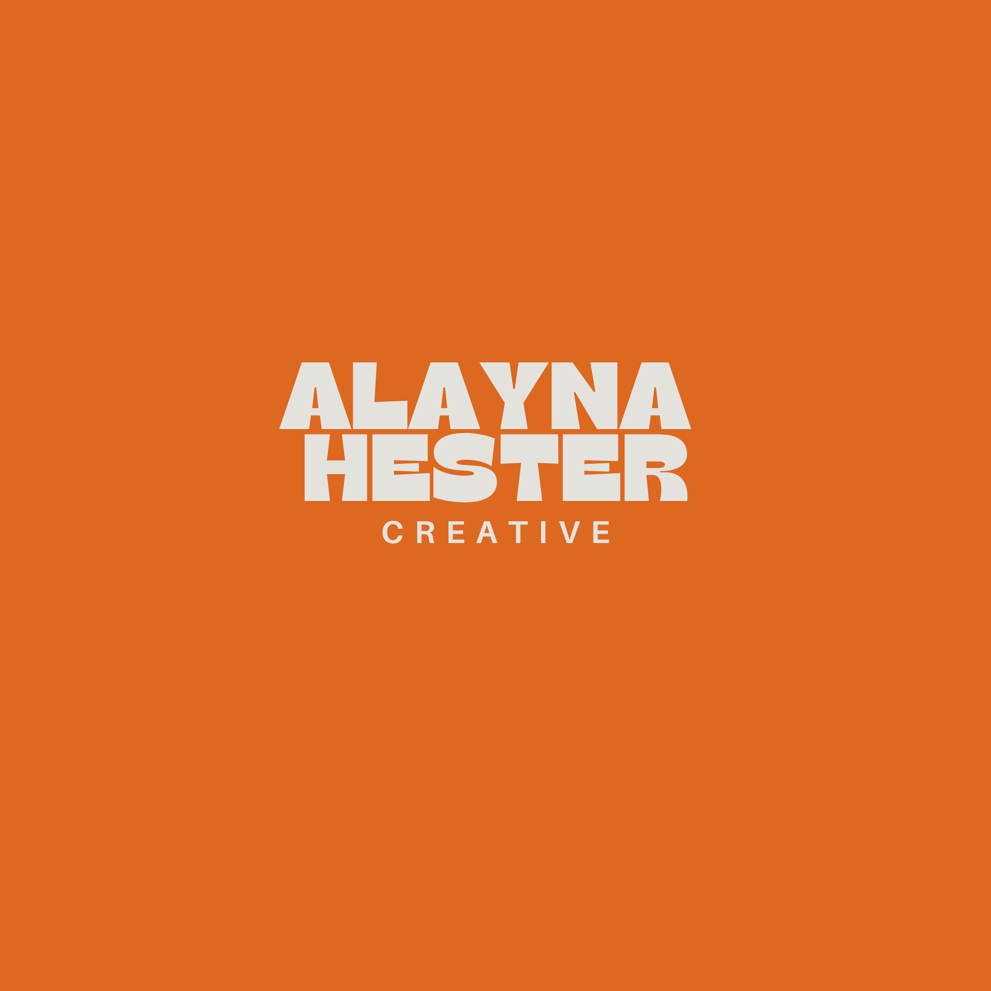 Yes, I am in a creative workspace with orange walls, featuring a sign that reads 'Alayna Testler Creative' in white text.