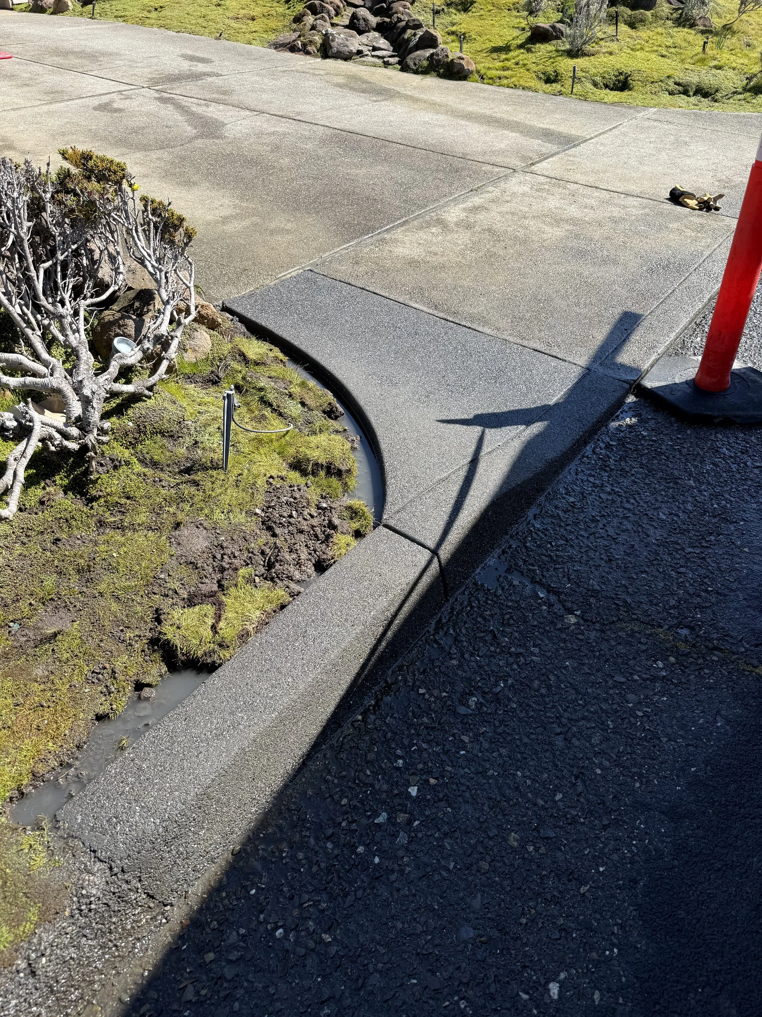 A sandwash concrete curb/apron with land black color added to concrete.