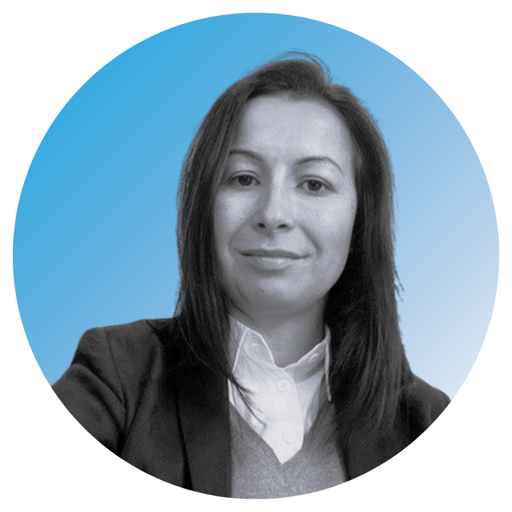 Black and white headshot of a woman with medium-length hair, wearing a blazer and collared shirt, against a blue circular background.
