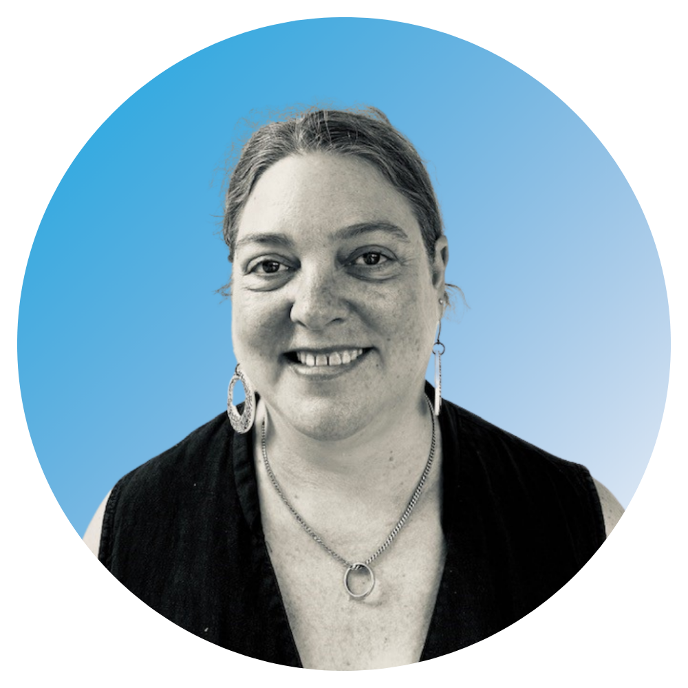 Black and white portrait of a smiling woman with earrings and necklaces, wearing a dark sleeveless top, against a blue digital background.