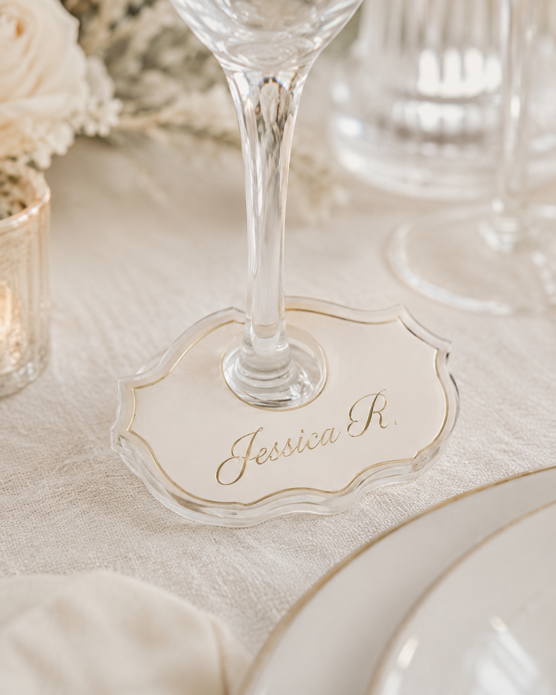 Glass of champagne on a table with a place card reading Jessica R.