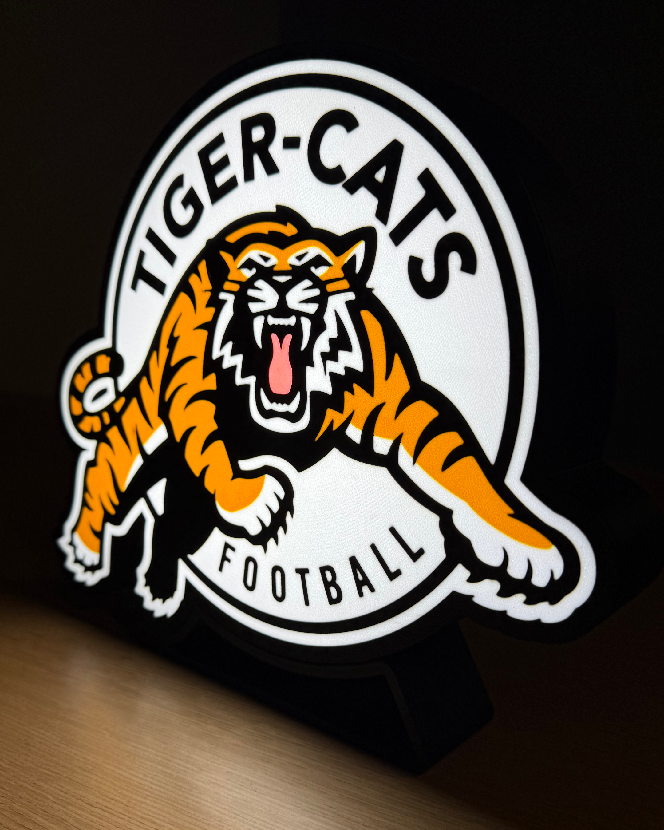 Illuminated Hamilton Tiger-Cats lightbox displayed on its stand against a dark background