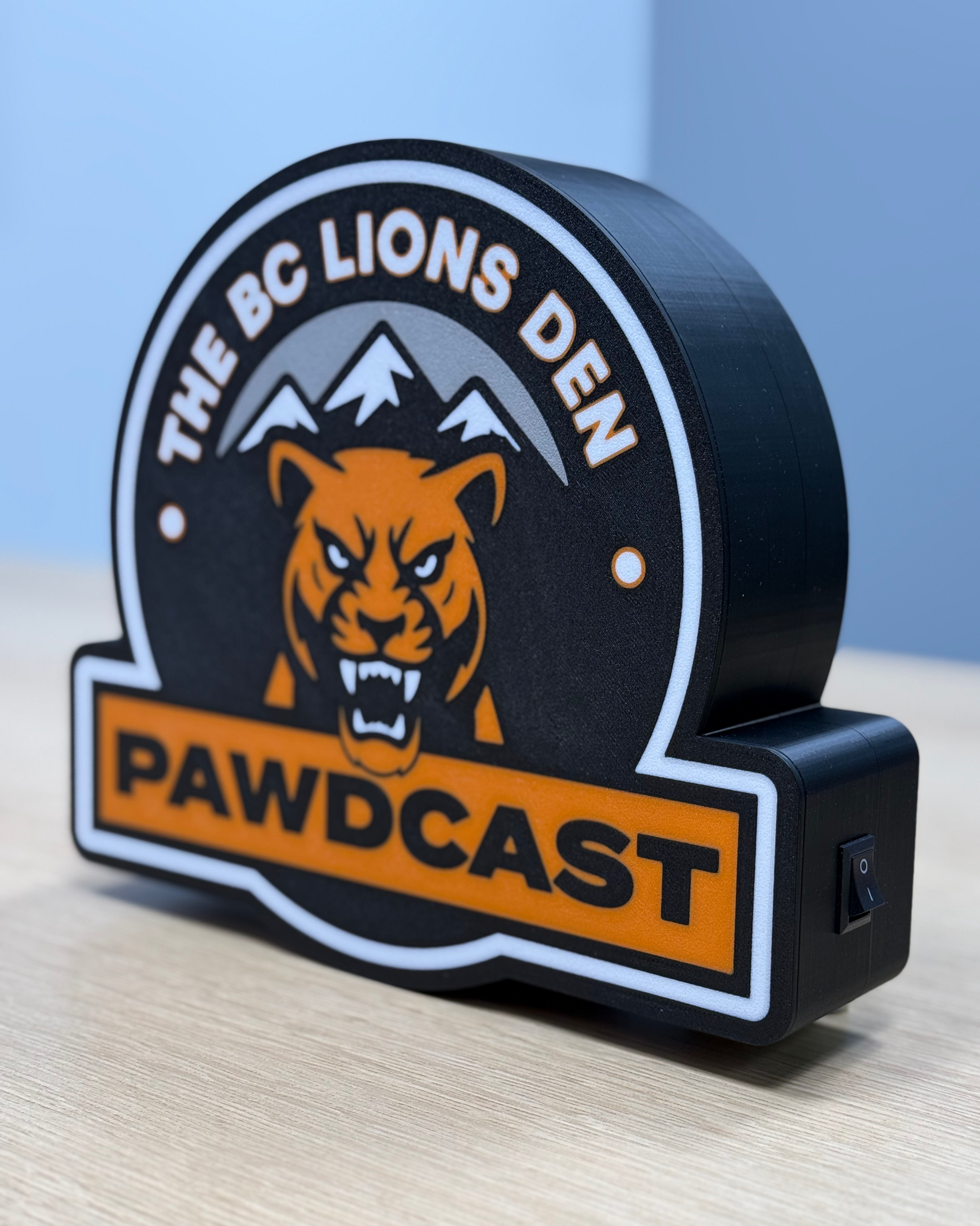 Angled view of the BC Lions Den Pawdcast lightbox showing the depth of the 3D-printed housing and side power switch