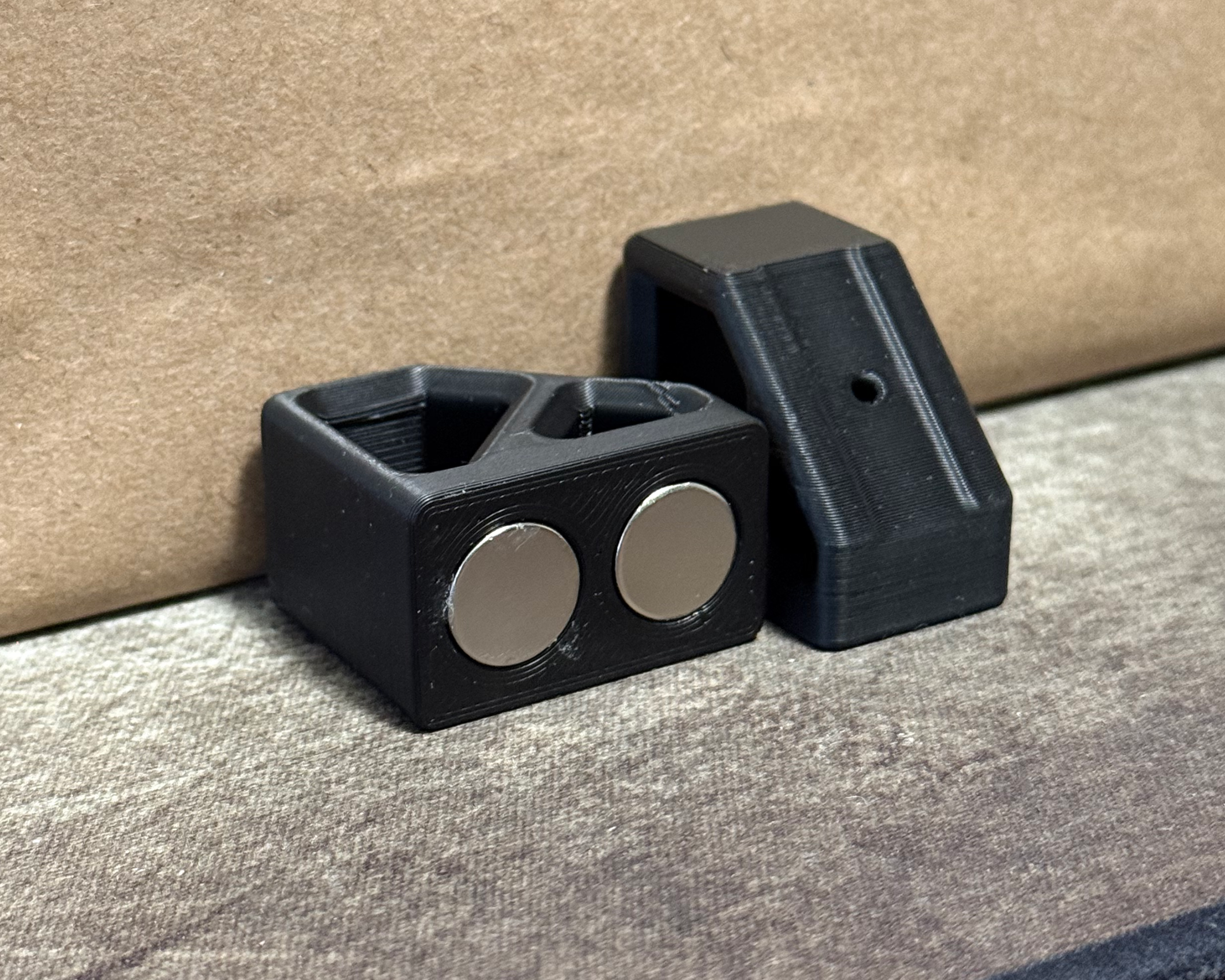 Close-up of the magnetic LED channel mounting components showing the embedded magnets and 3D-printed housings