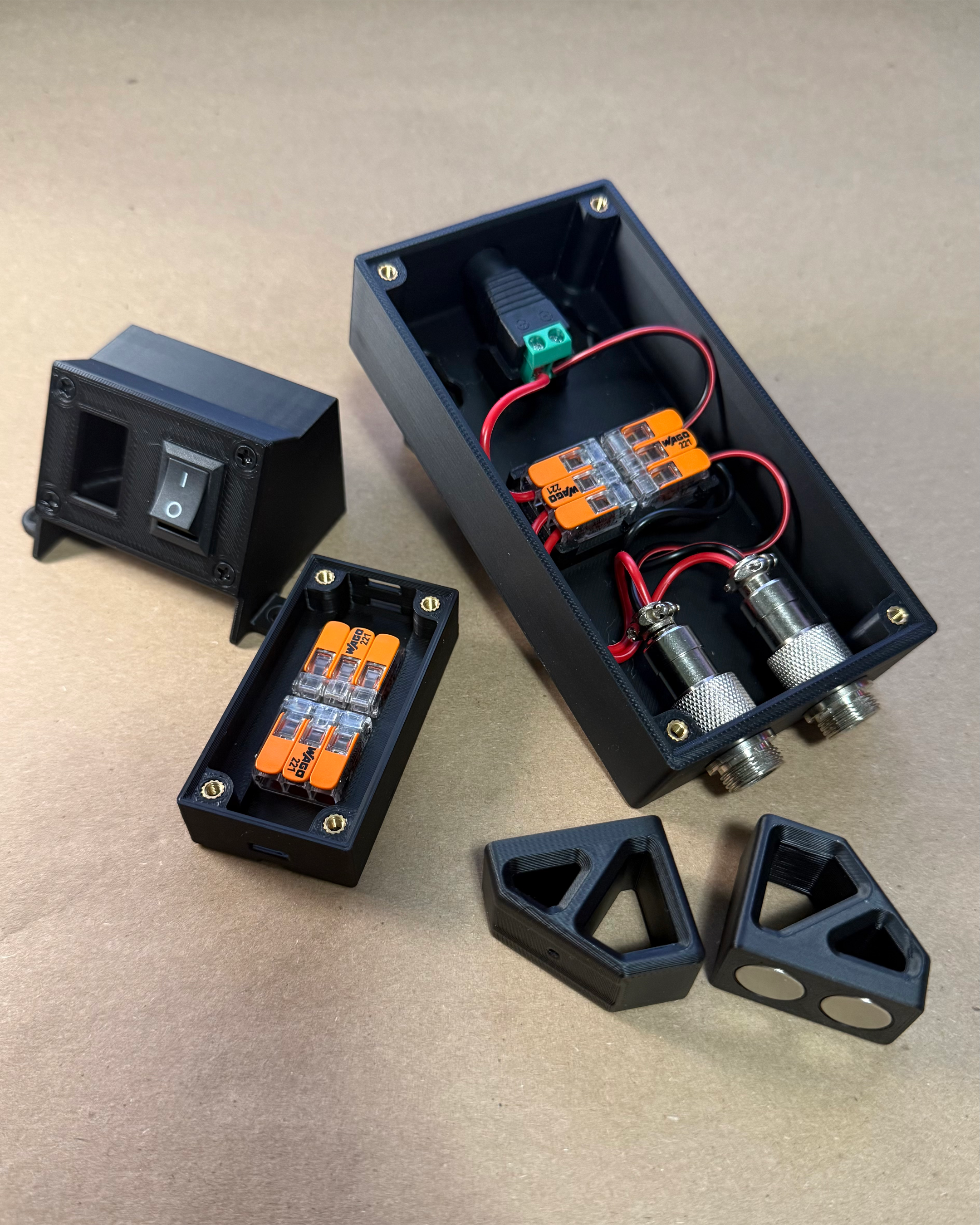 Group view of the custom 3D-printed workbench lighting components, including switch, wiring, connector, and magnetic mounting enclosures
