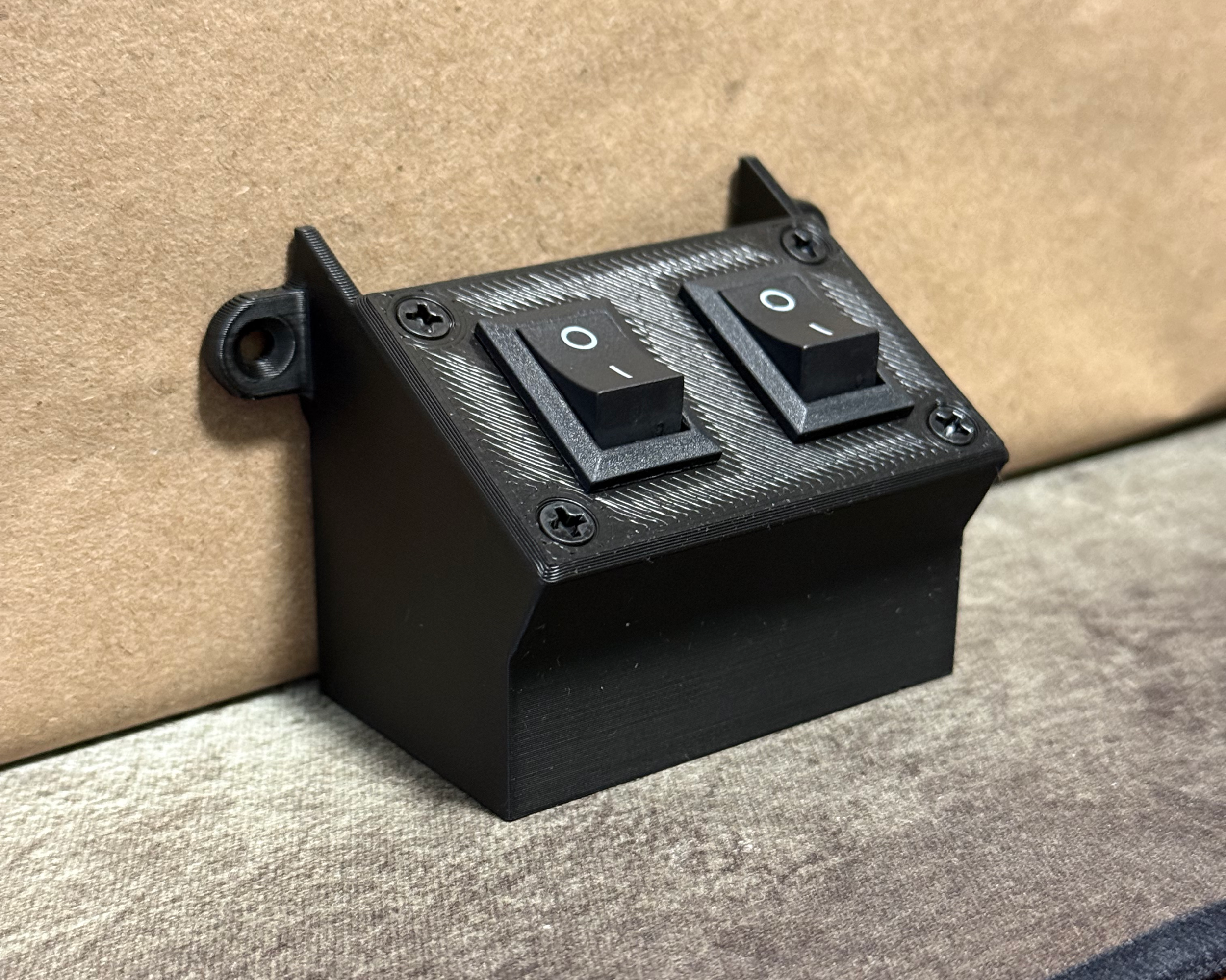 Angled view of the dual-switch enclosure showing the two rocker switches and 3D-printed mounting housing