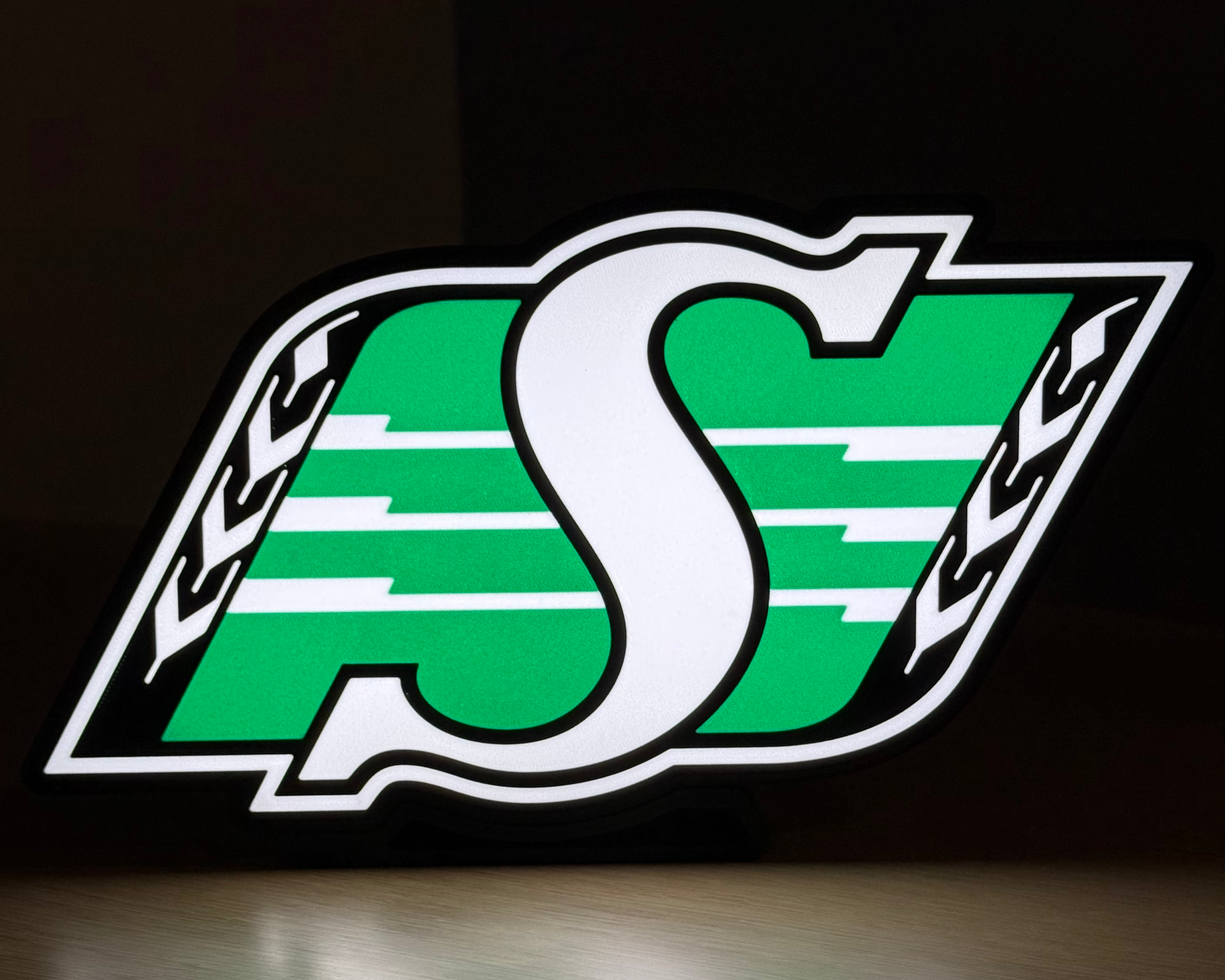 Illuminated front view of the Saskatchewan Roughriders logo lightbox against a dark background