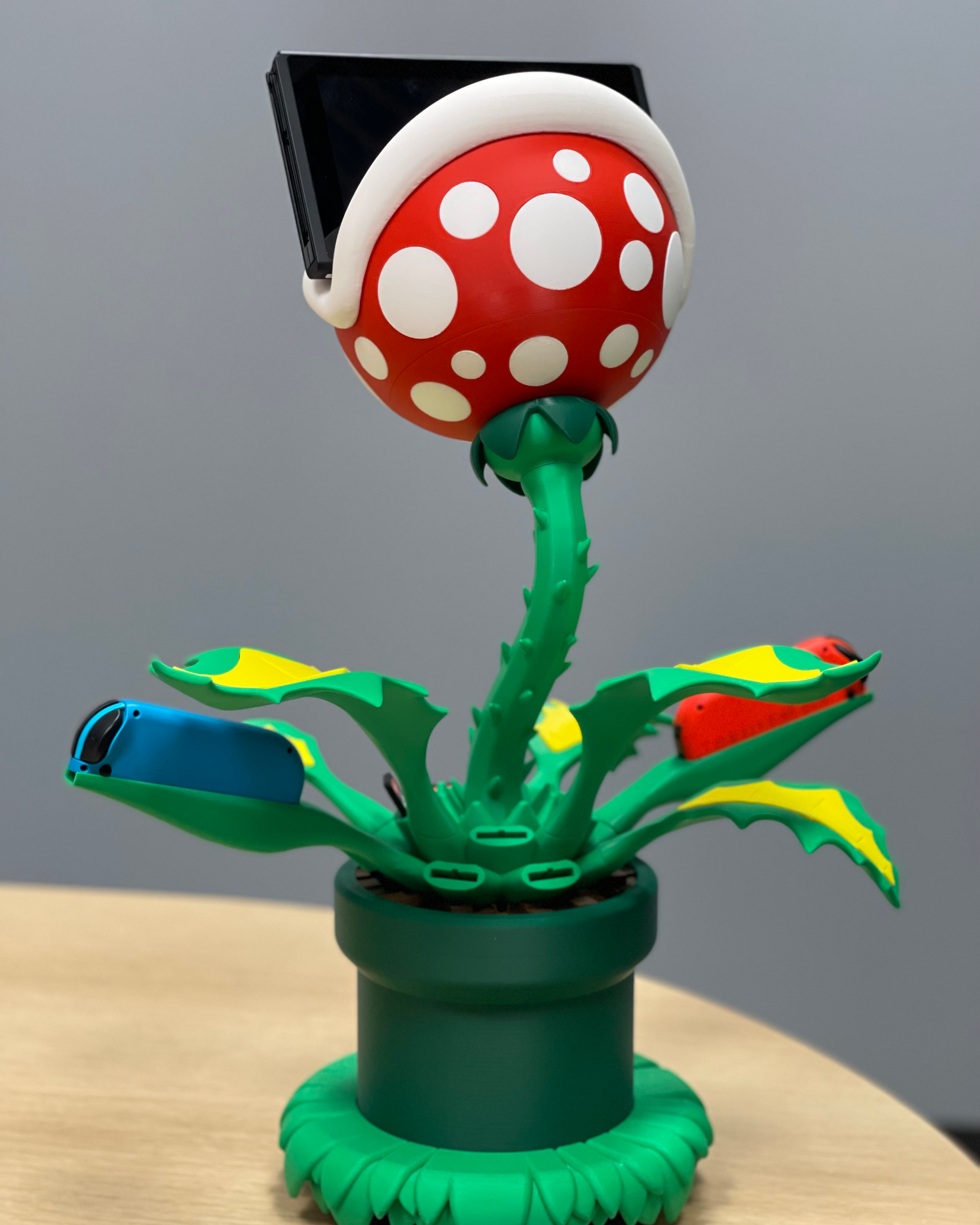 Rear view of the Piranha Plant dock showing the Nintendo Switch, Joy-Con controllers, branching leaves, and 3D-printed structure