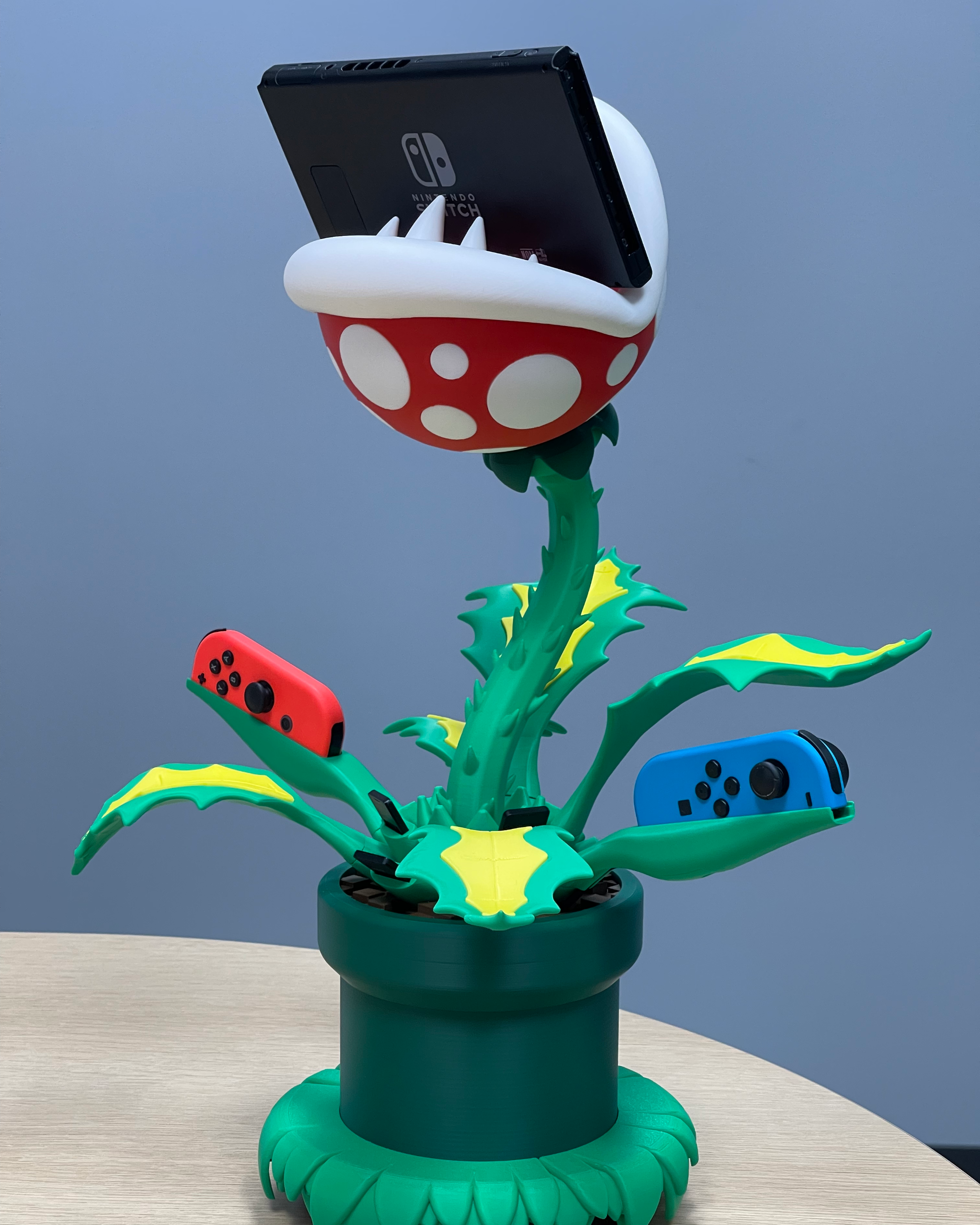 Three-quarter view of the Piranha Plant dock showing the Nintendo Switch in the plant’s mouth and Joy-Con controllers held in the surrounding leaves
