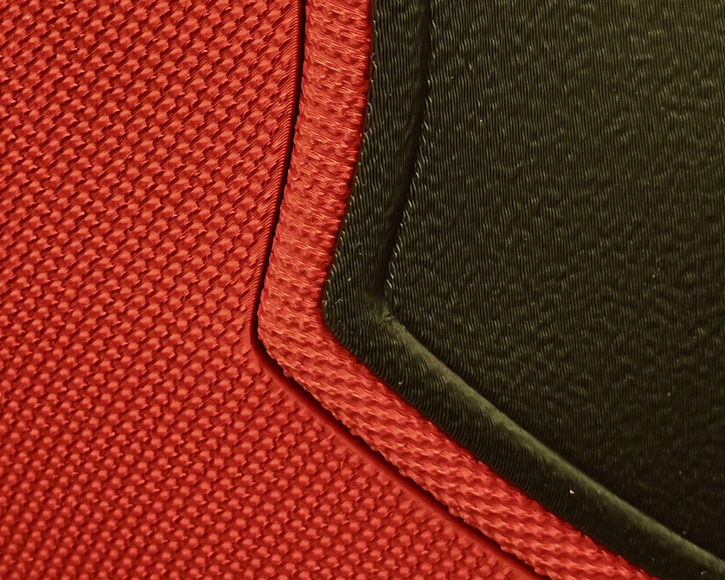 Macro detail of the Deadpool mask showing the transition between the red textured shell and black eye panel
