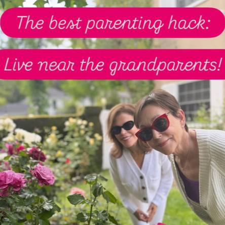 Pam and Leslie smiling outdoors in a garden with pink and white flowers, wearing sunglasses, with one woman taking a selfie. The image has a pink banner with white text that reads, 'The best parenting hack: Live near the grandparents!'