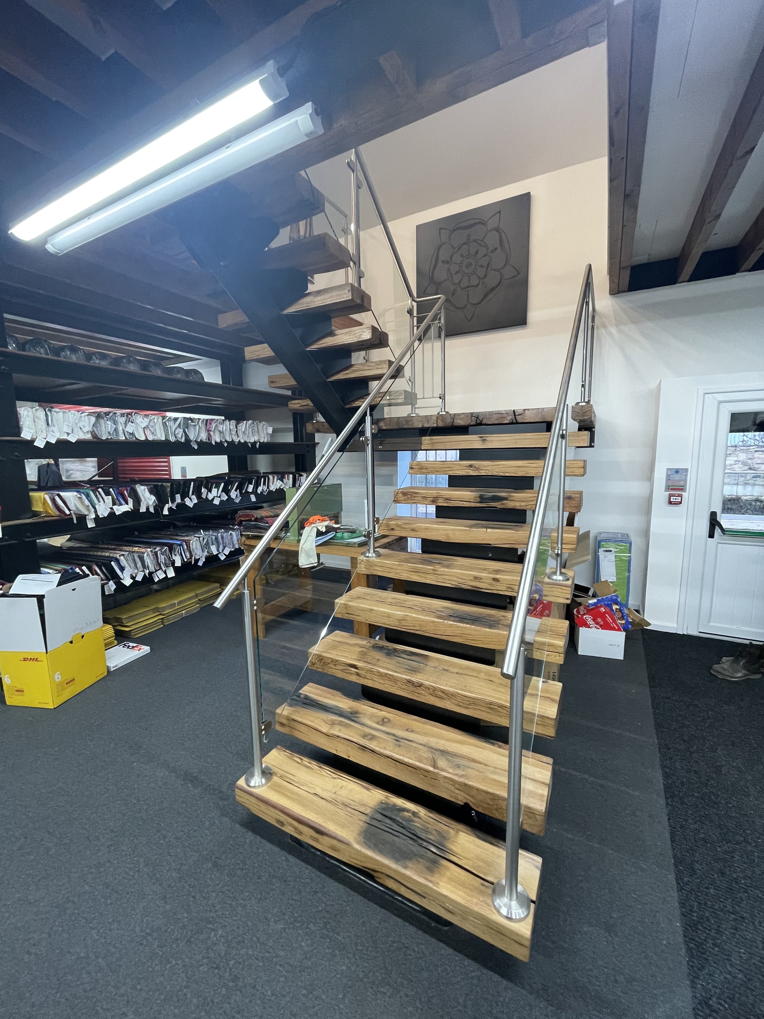 Steel spine staircase with oak treads, finished with a stainless steel handrail and glass infill panels.