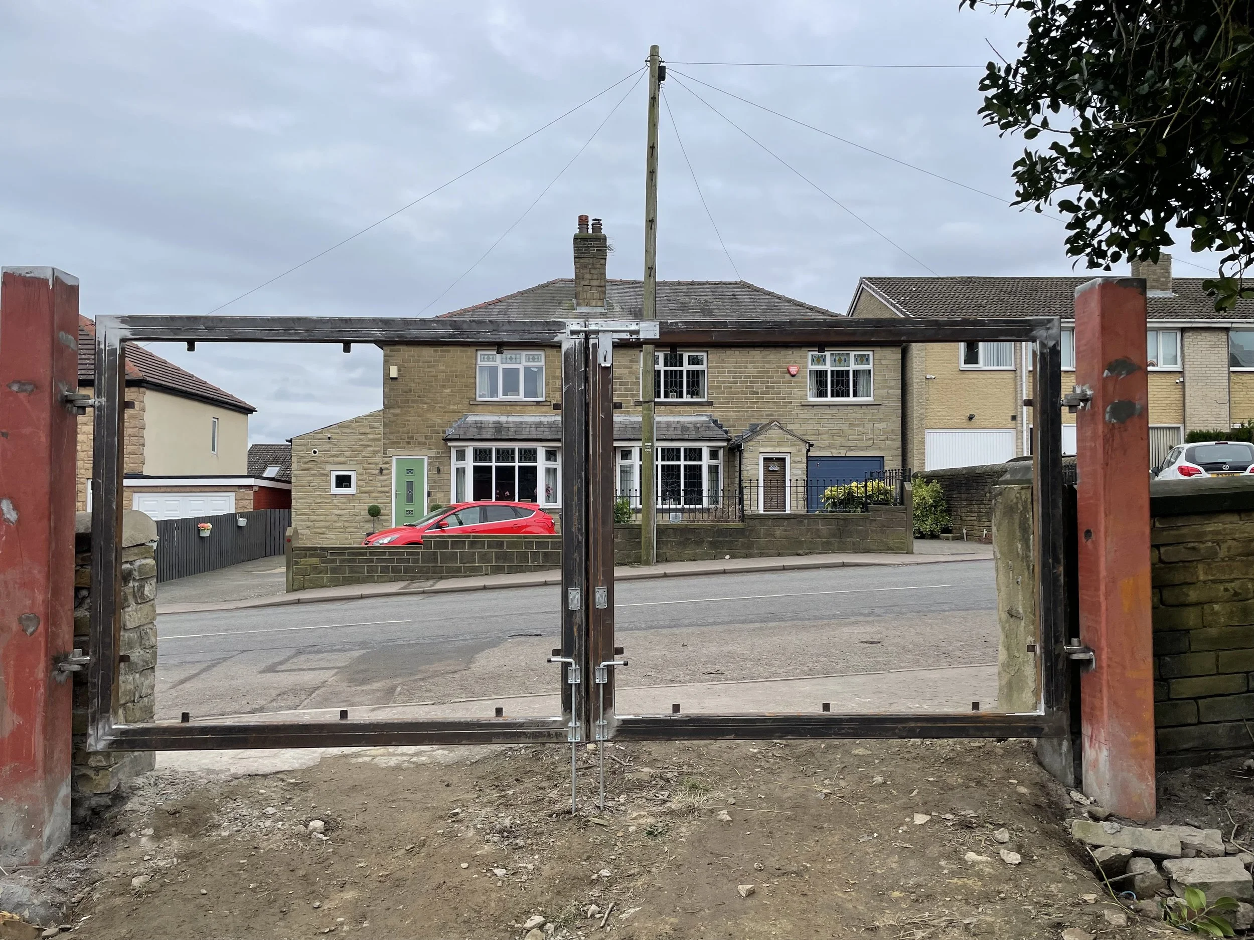 Driveway gates fabricated on site, designed to take decorative laser-cut steel panels, with steel posts fabricated and installed as part of the project.