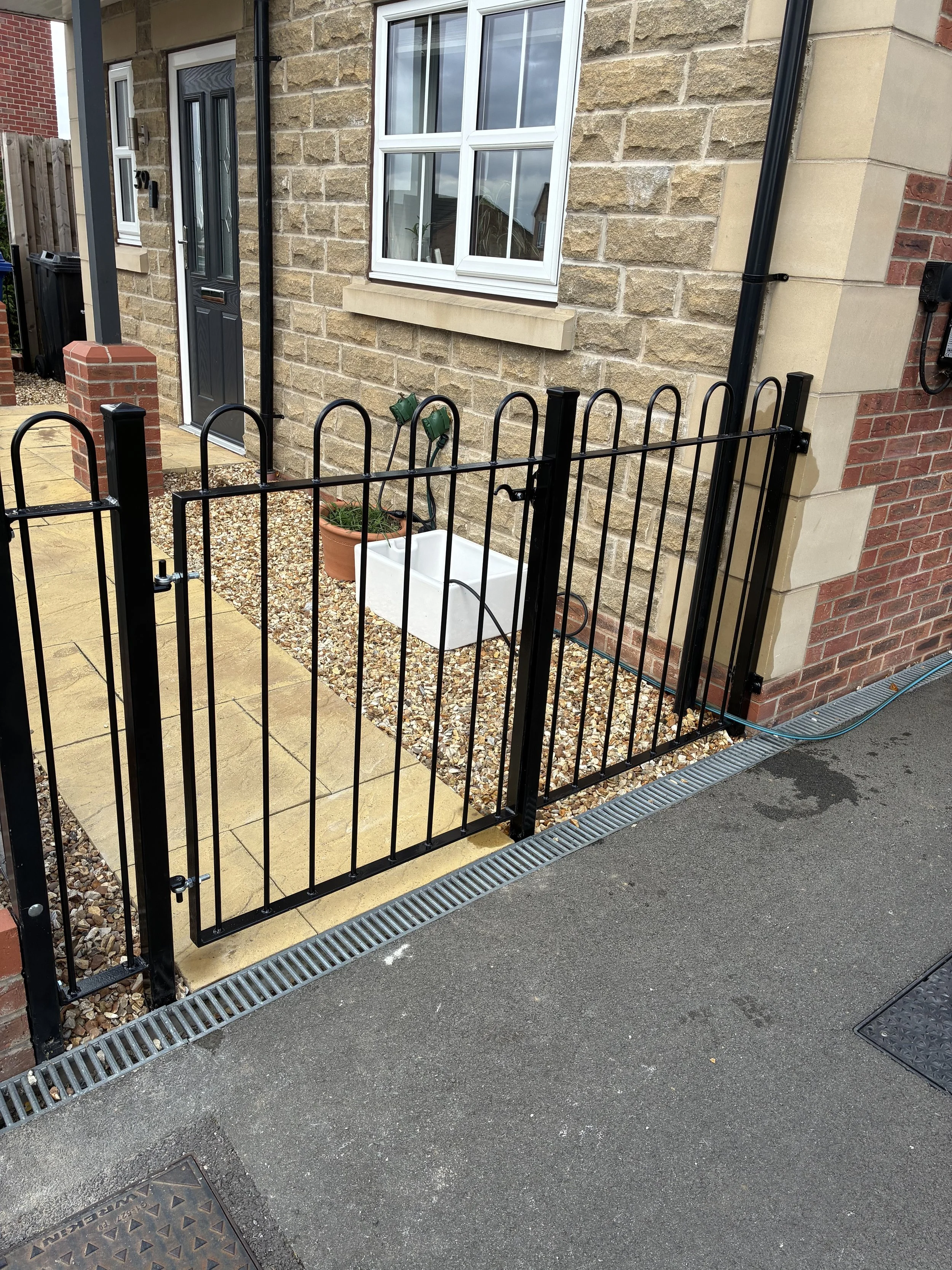 Bespoke hoop top wrought iron railings, manufactured and installed by Sharland Steelworks in Barnsley, South Yorkshire. Traditional curved steel railing design with a durable black finish, combining classic styling with quality craftsmanship.