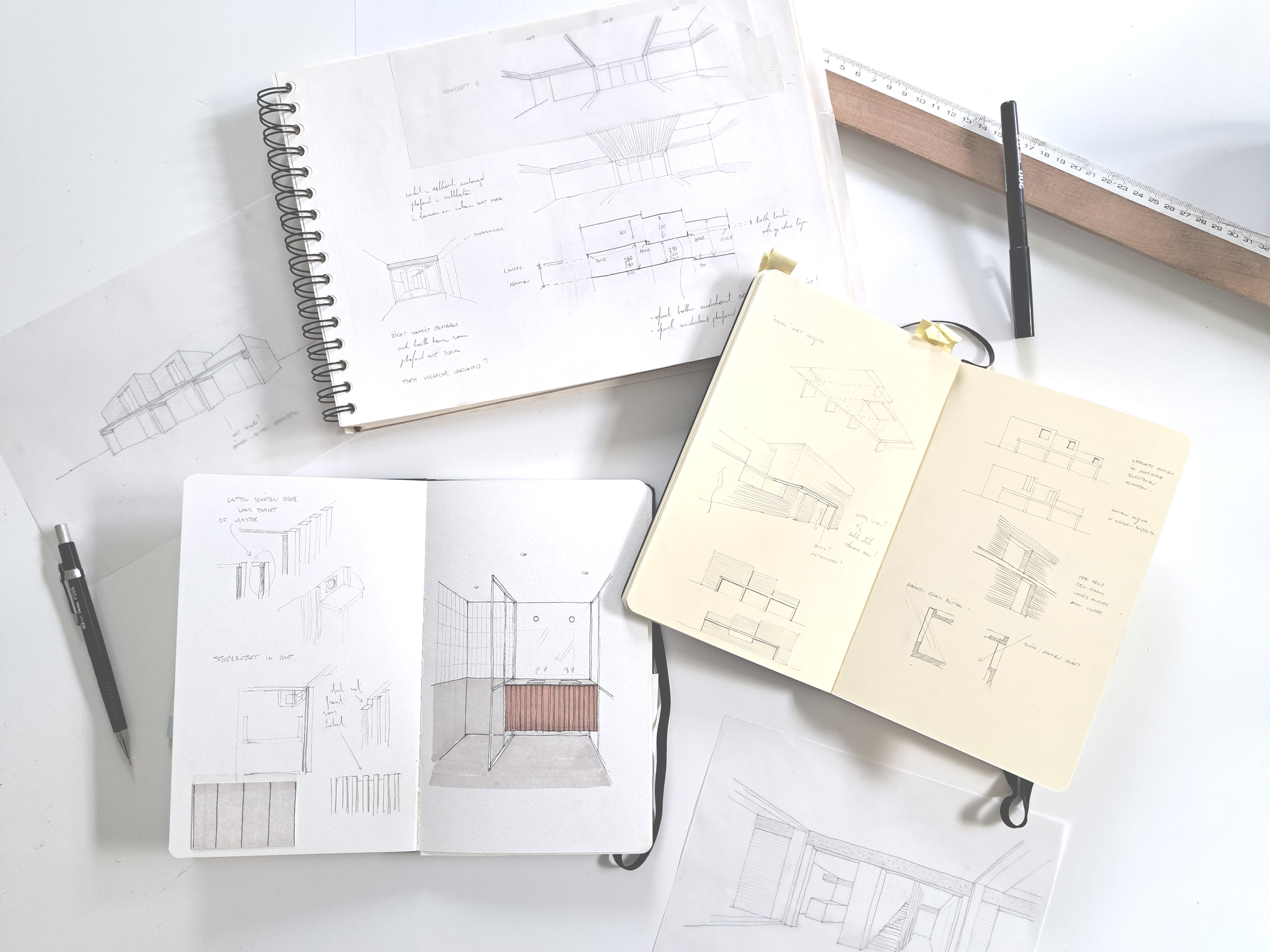Schetsboeken en tekeningen van architectuurontwerpen, met technische tekeningen en ontwerpen voor binnenruimtes, architectonische concepten, en bouwplannen. Er ligt een liniaal en een pen naast.