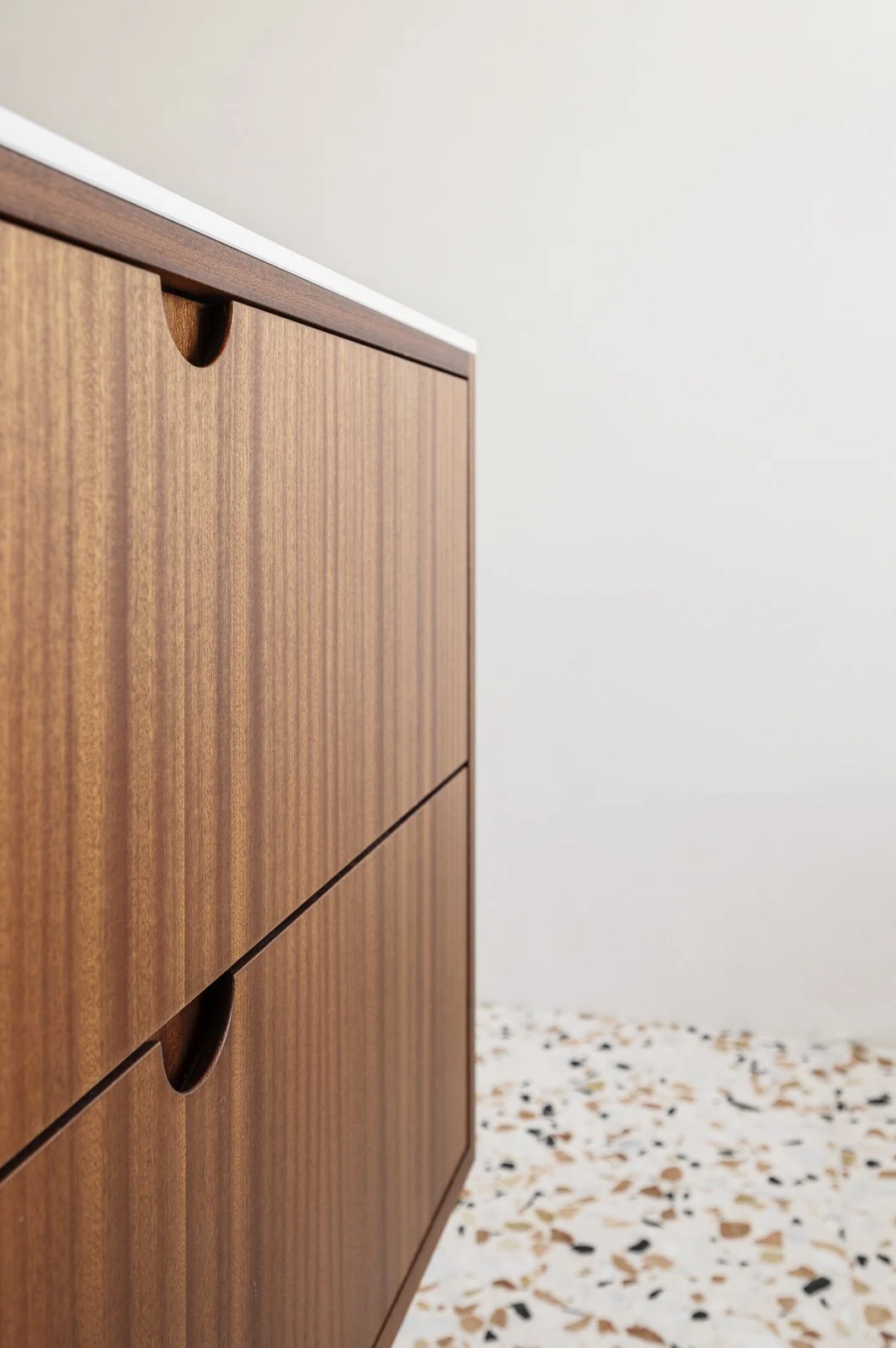 Mooie houten kast met ronde handgrepen in een minimalistisch interieur.