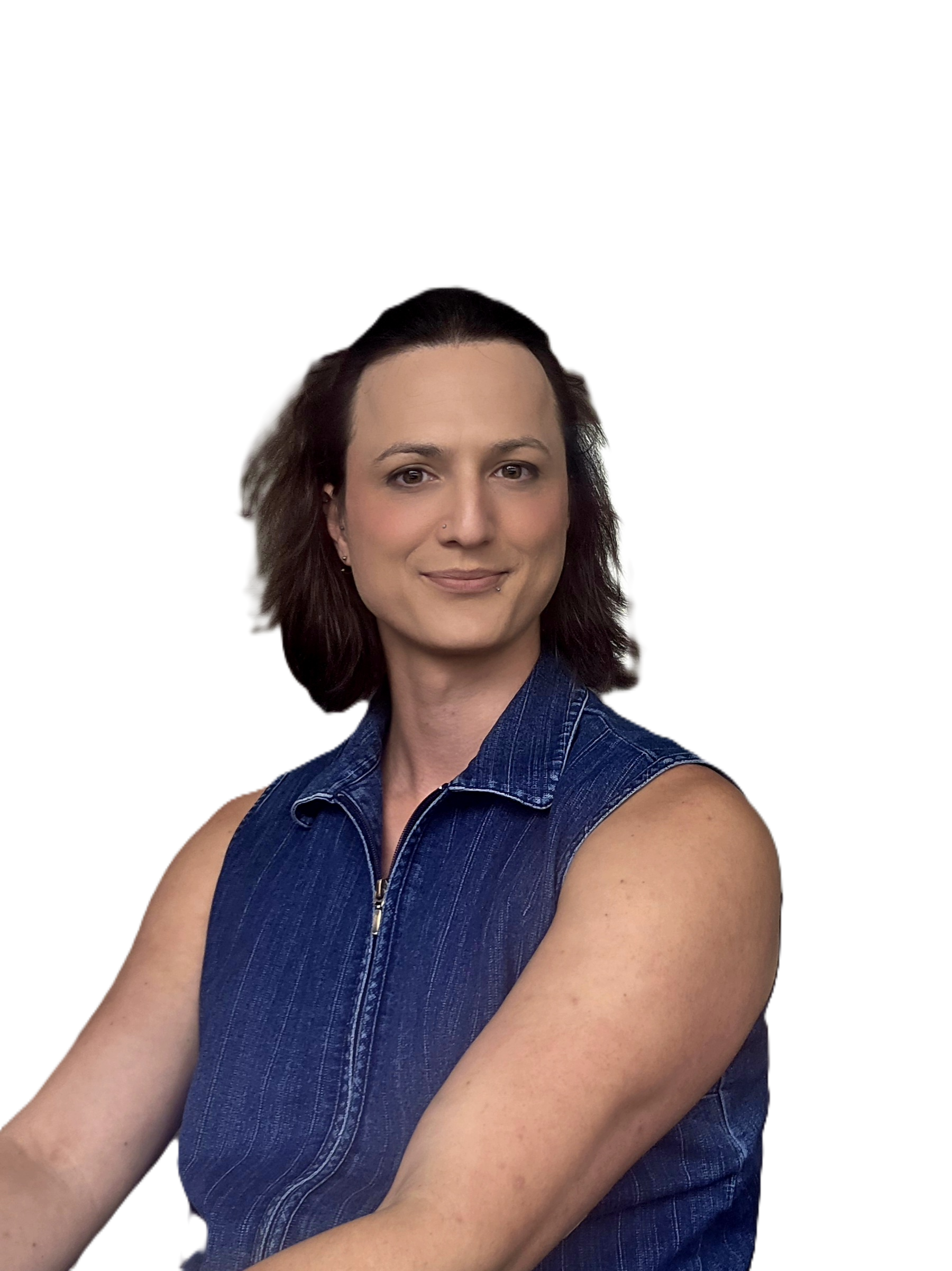 A woman with shoulder-length dark hair, wearing a blue sleeveless denim shirt, smiling with arms crossed.