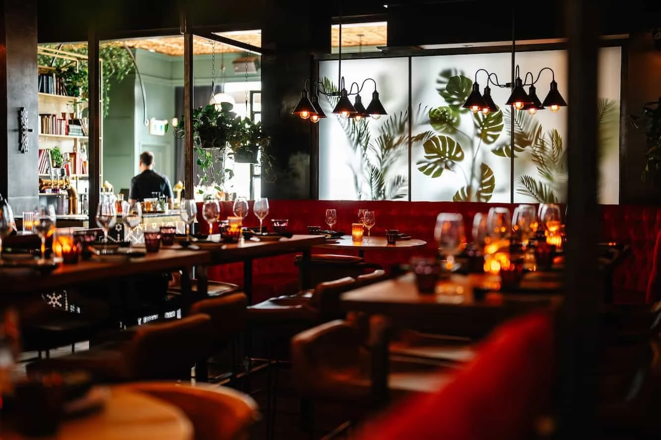 Madame Bovary restaurant interior in Laval with intimate dining zones, red banquettes and layered lighting by Chrome Design