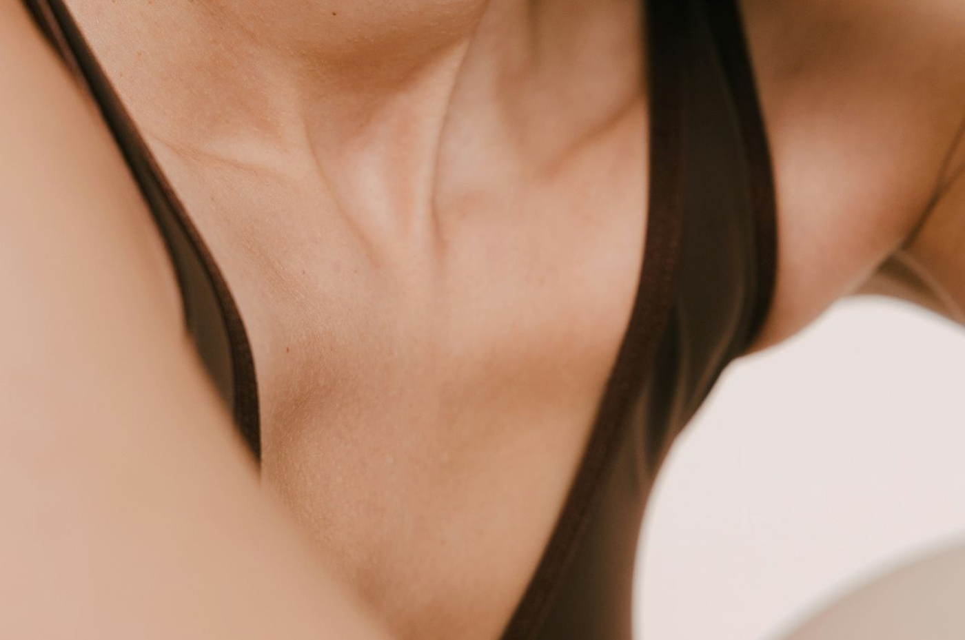 Close-up of a woman's cleavage wearing a black tank top.