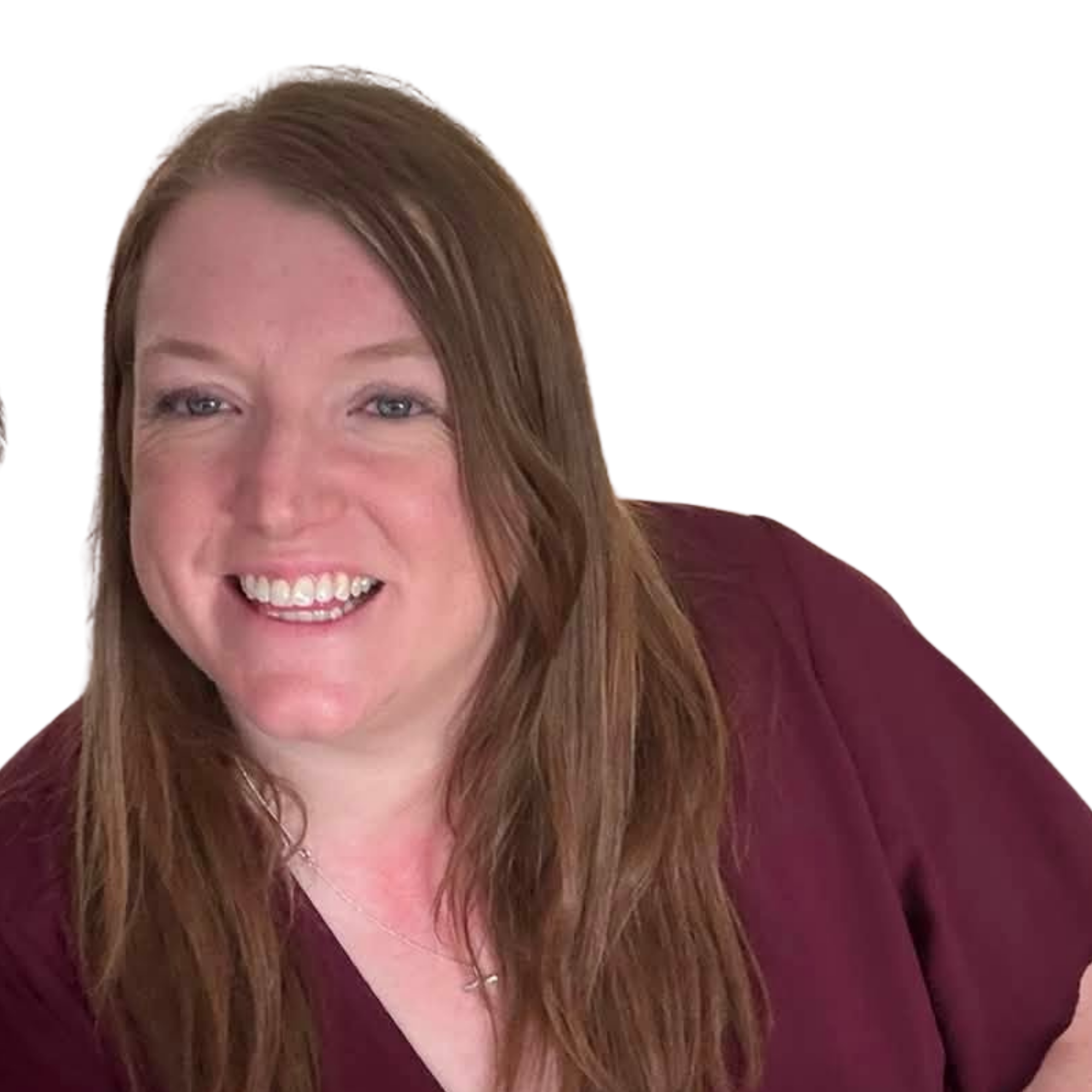 Close-up of a woman with long red hair, blue eyes, smiling, wearing a maroon top.