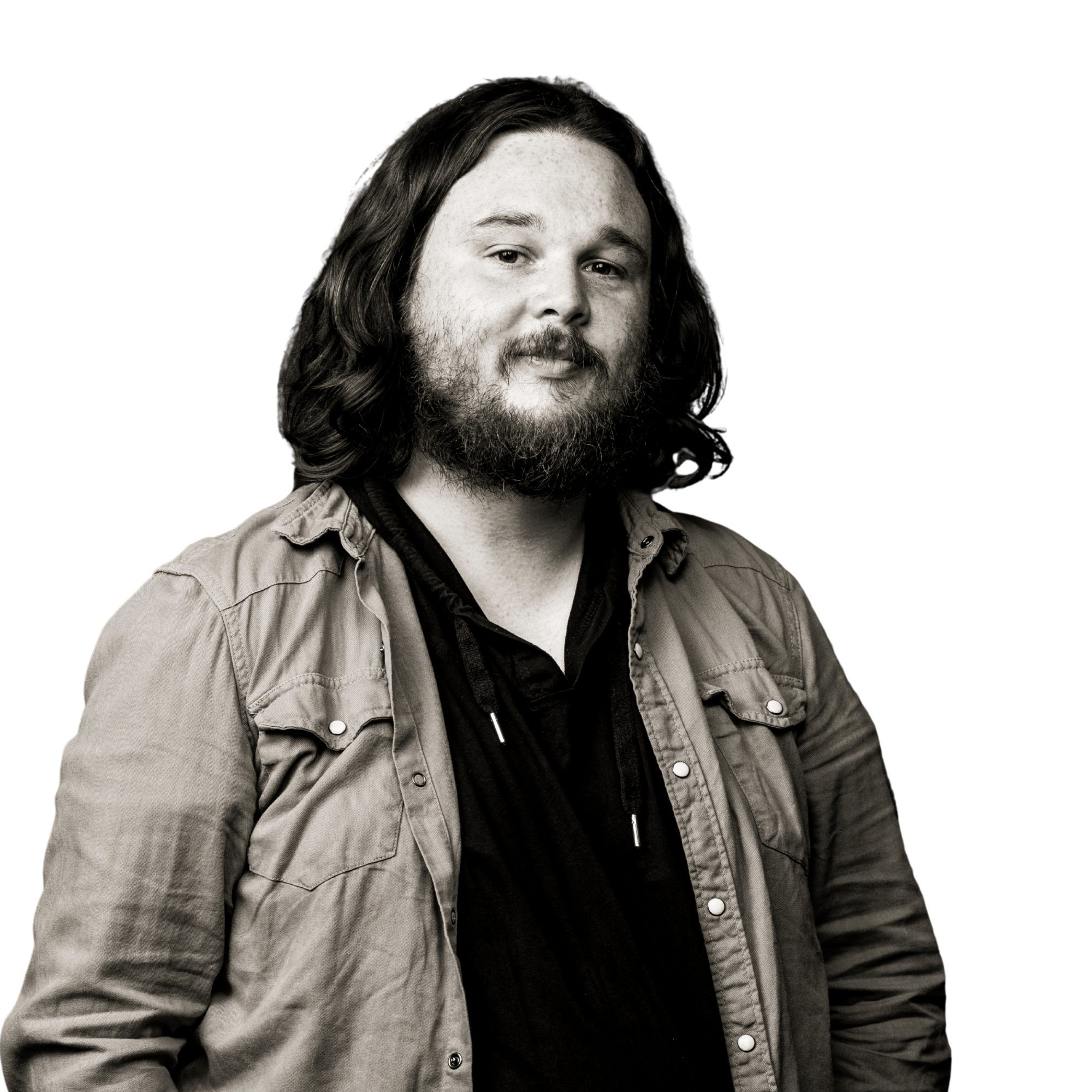 Black and white portrait of a man with long, wavy hair and a full beard, wearing a jacket over a shirt, against a dark background.